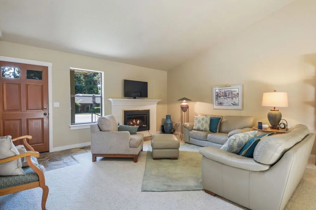A wooden front door opens onto the stone entry of the living room with a cozy propane fireplace.