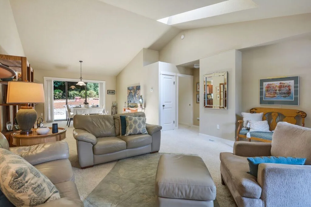 The vaulted ceiling provides a spacious feeling to this open floor plan, and the skylight keeps the room bright with natural light. Notice the coat closet under the skylight.