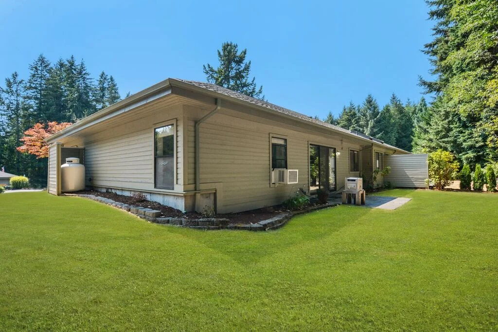 Another view of the lawn from the back corner of the lot looking toward the back bedroom windows, and the sliding doors into the dining room.