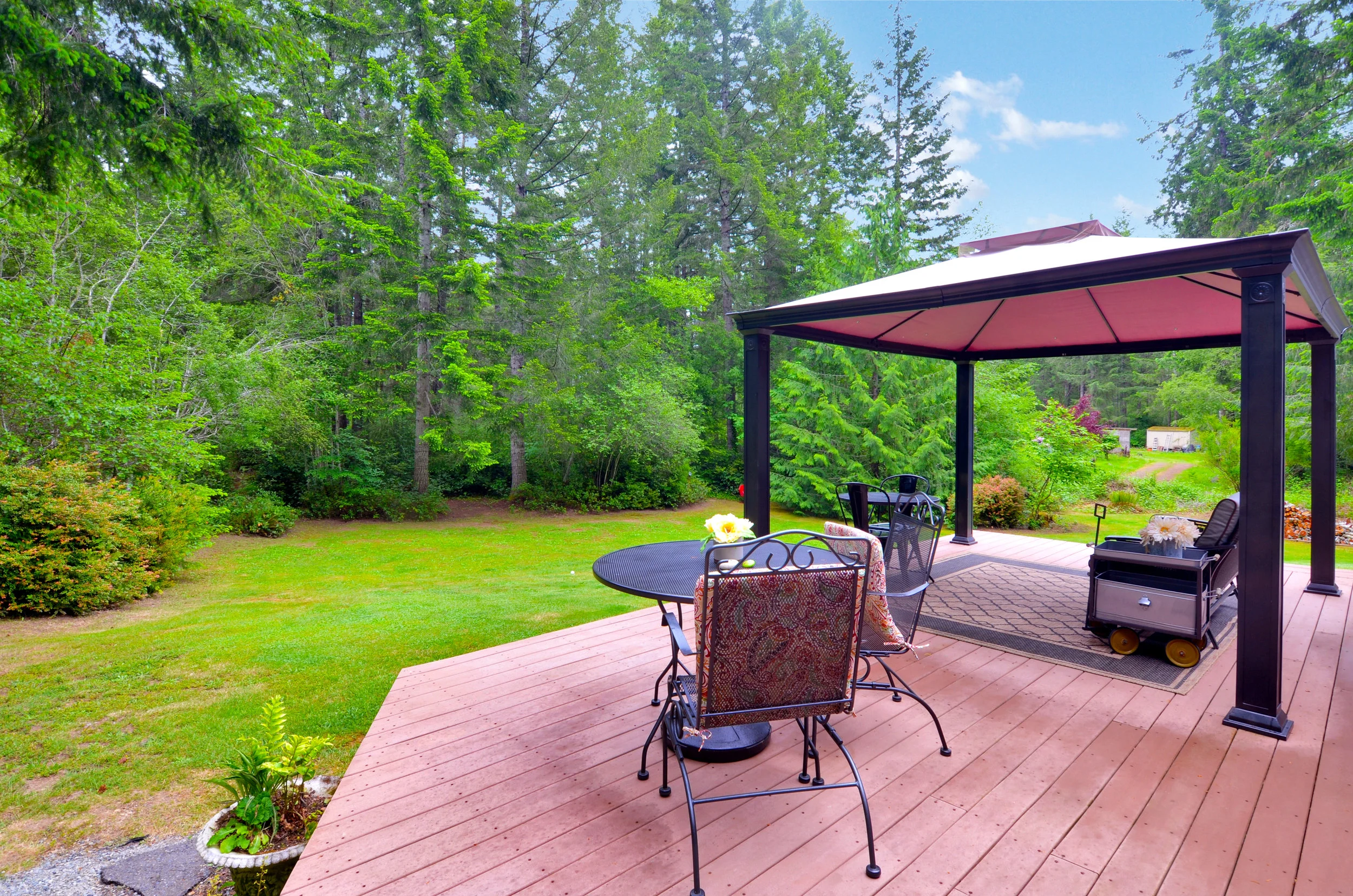 The spacious back deck overlooks the back yard and woods where Douglas fir, cedar, alder, and huckleberry thrive. The screen house stays, so you'll be all set to enjoy its shade this summer!