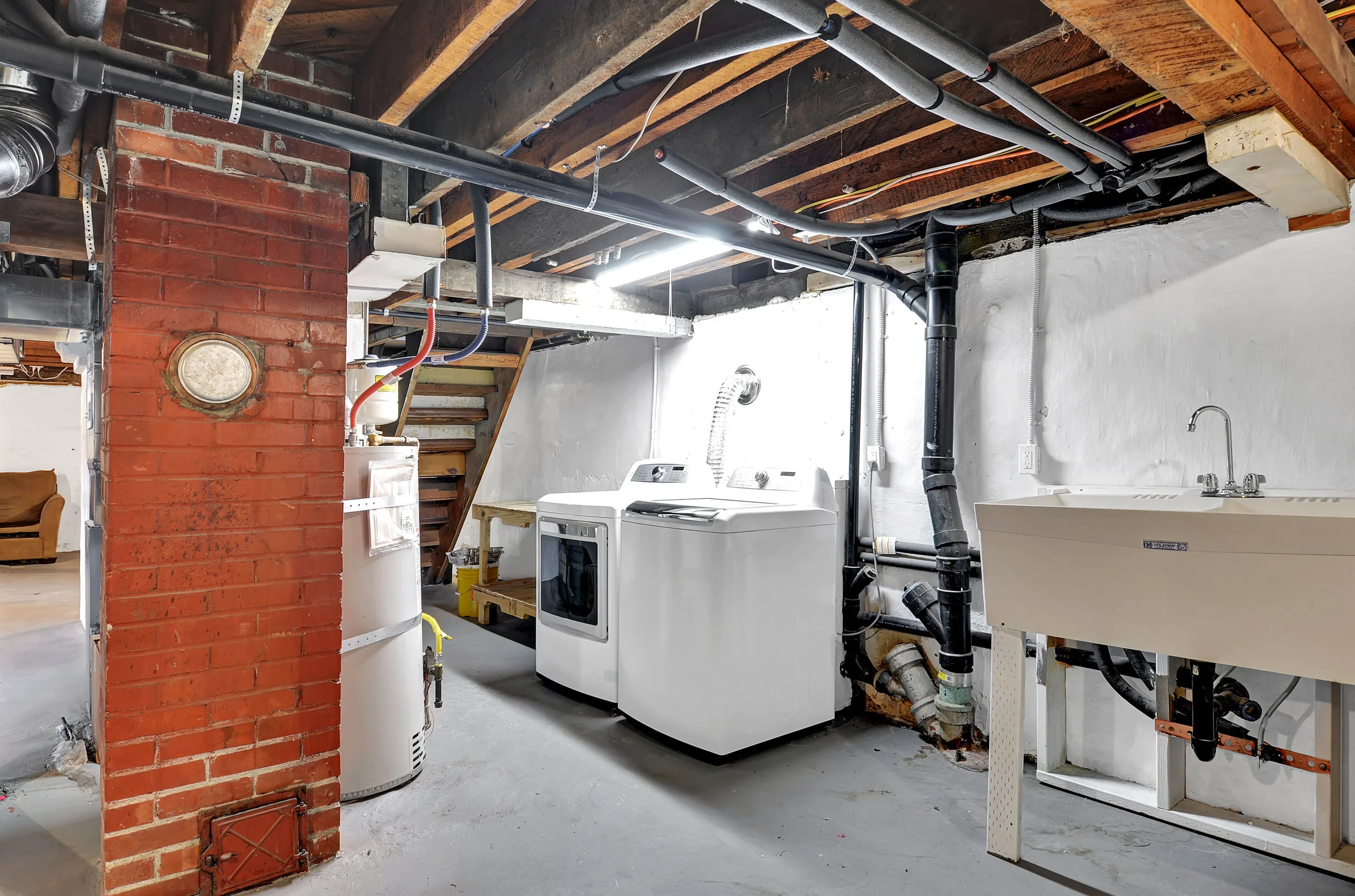 The laundry area is located in the basement with a large, practical utility sink beside.