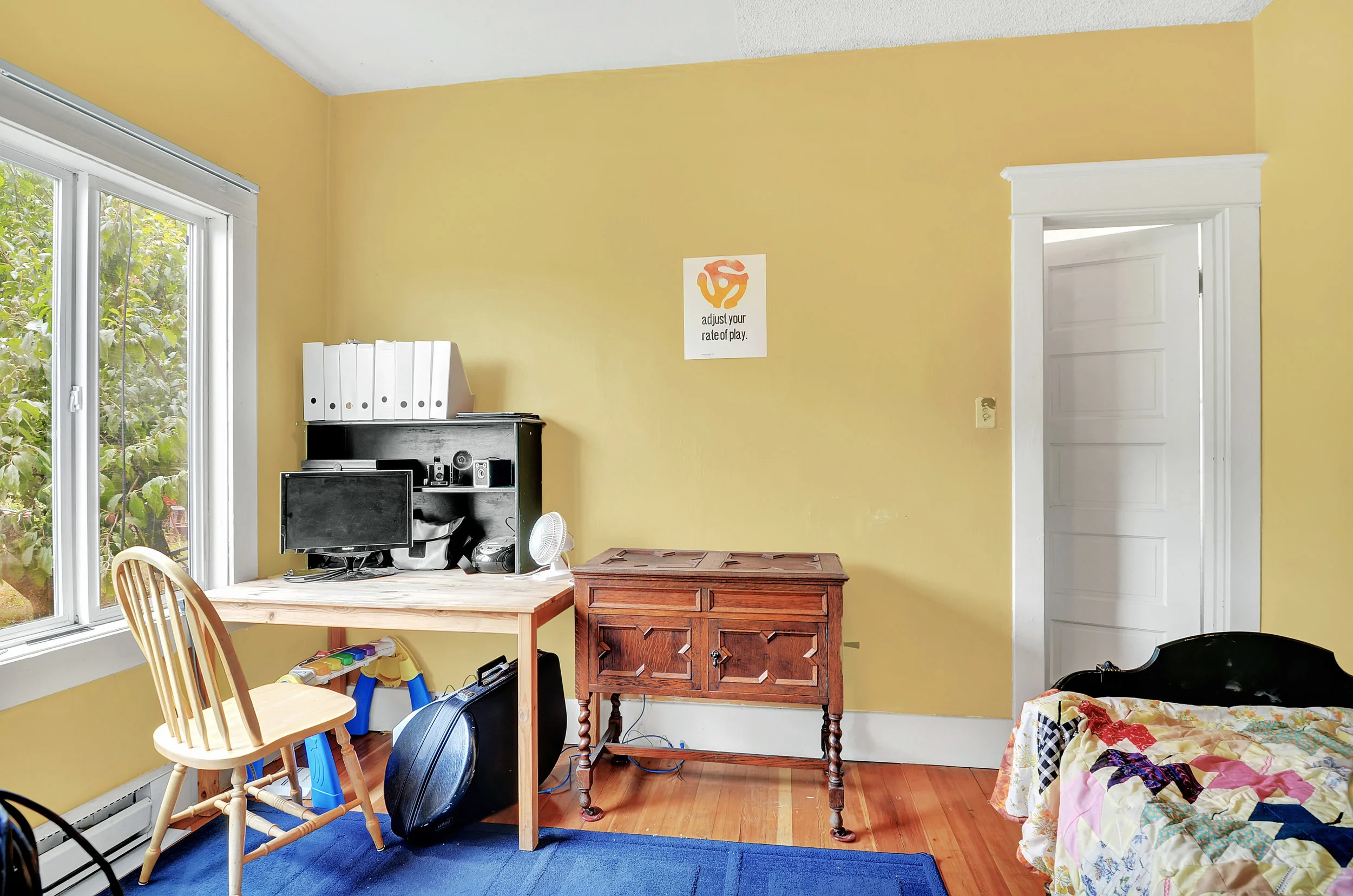 This main floor bedroom is set at the back of the house off the dining room and near the kitchen. Fir floors make it cozy and high ceilings give a nice sense of space.