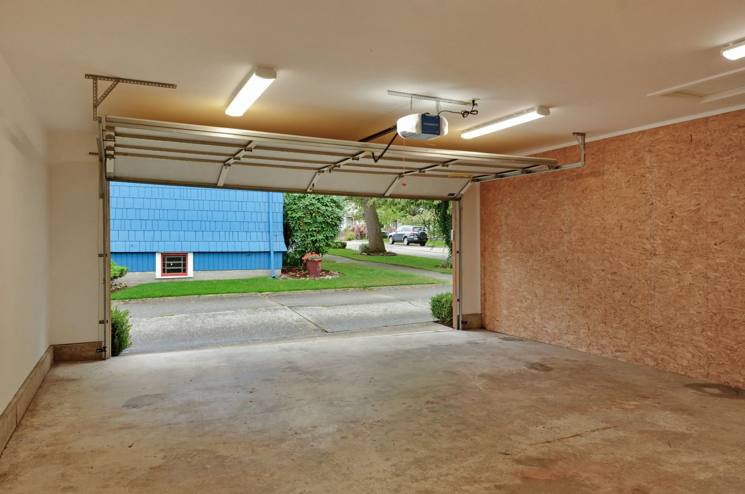 An automatic door opens from the paved alley into a clean bright space. A window on the east wall of the garage overlooks the back yard and garden.