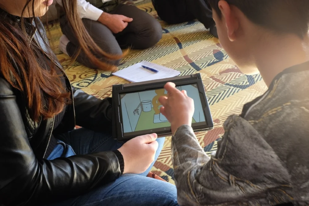 A Yazidi child pointing to the things he doesn’t like about the current latrines via the digital tool.  