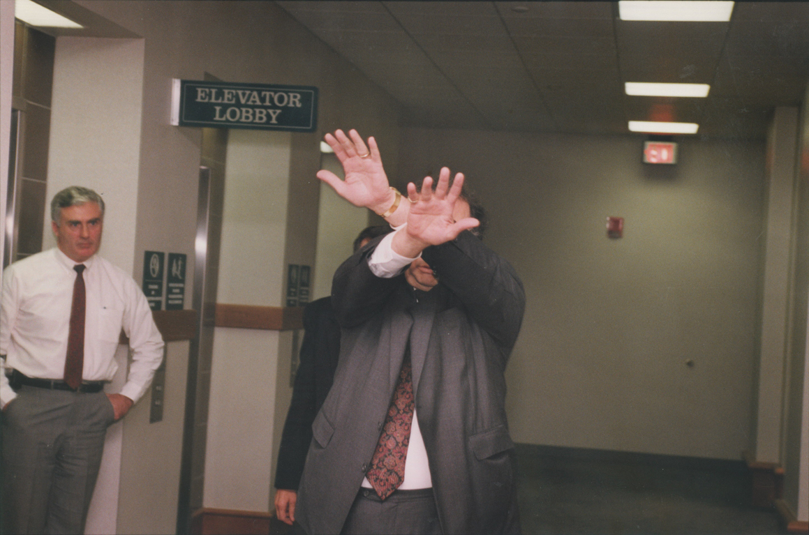 Robert Barbato hides his face in November 1991. Barbato's decades-long friendship with Bevilacqua drew media scrutiny when Bevilacqua became Chief Justice of the Rhode Island Supreme Court. Courtesy of The Providence Journal/Mary Murphy.