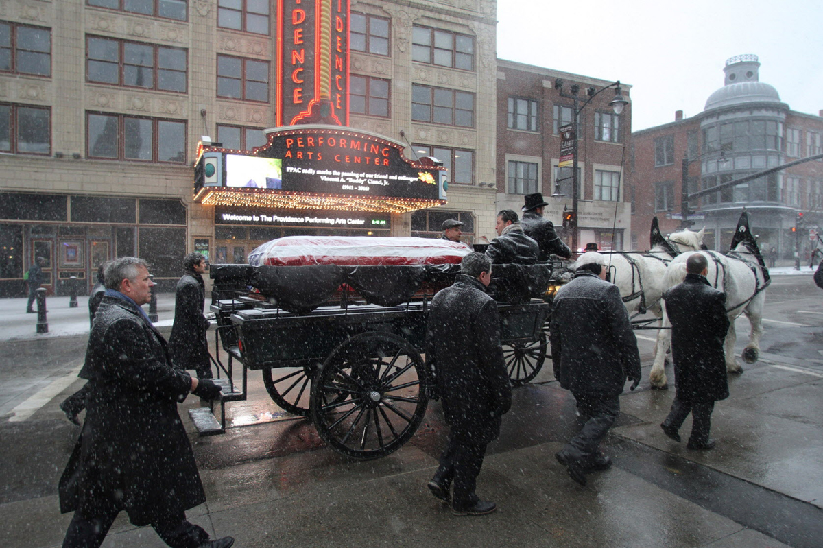 Joseph Paolino, left, and others walk beside the horse-drawn carriage carrying Buddy Cianci's body on the way to the Cathedral of Saints Peter and Paul. Courtesy of The Providence Journal/Steve Szydlowski.