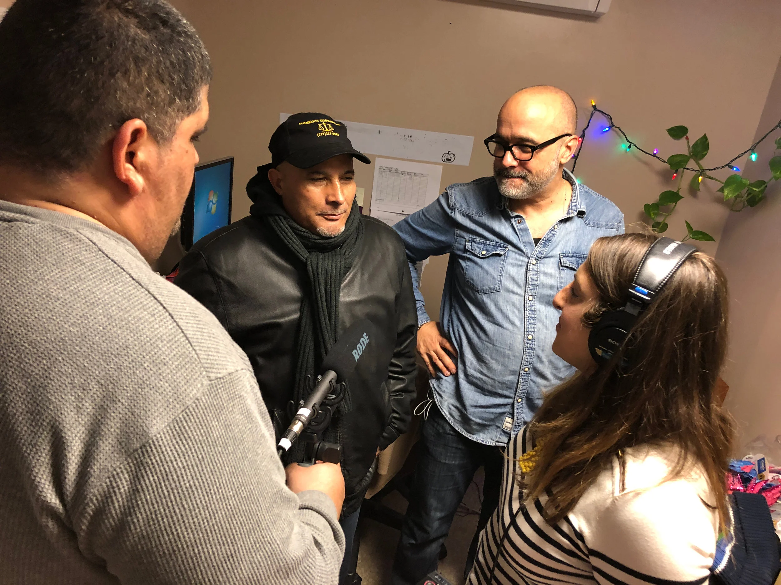 Mugianis, second from right, now works at a harm reduction agency in East Harlem, New York. The program includes a holistic activities such as yoga, acupuncture, and tai chi. Here, Crimetown producer Samantha Lee, right, talks with Mugianis and two of his clients, one of whom offered a bit of production help. Photo by Drew Nelles.