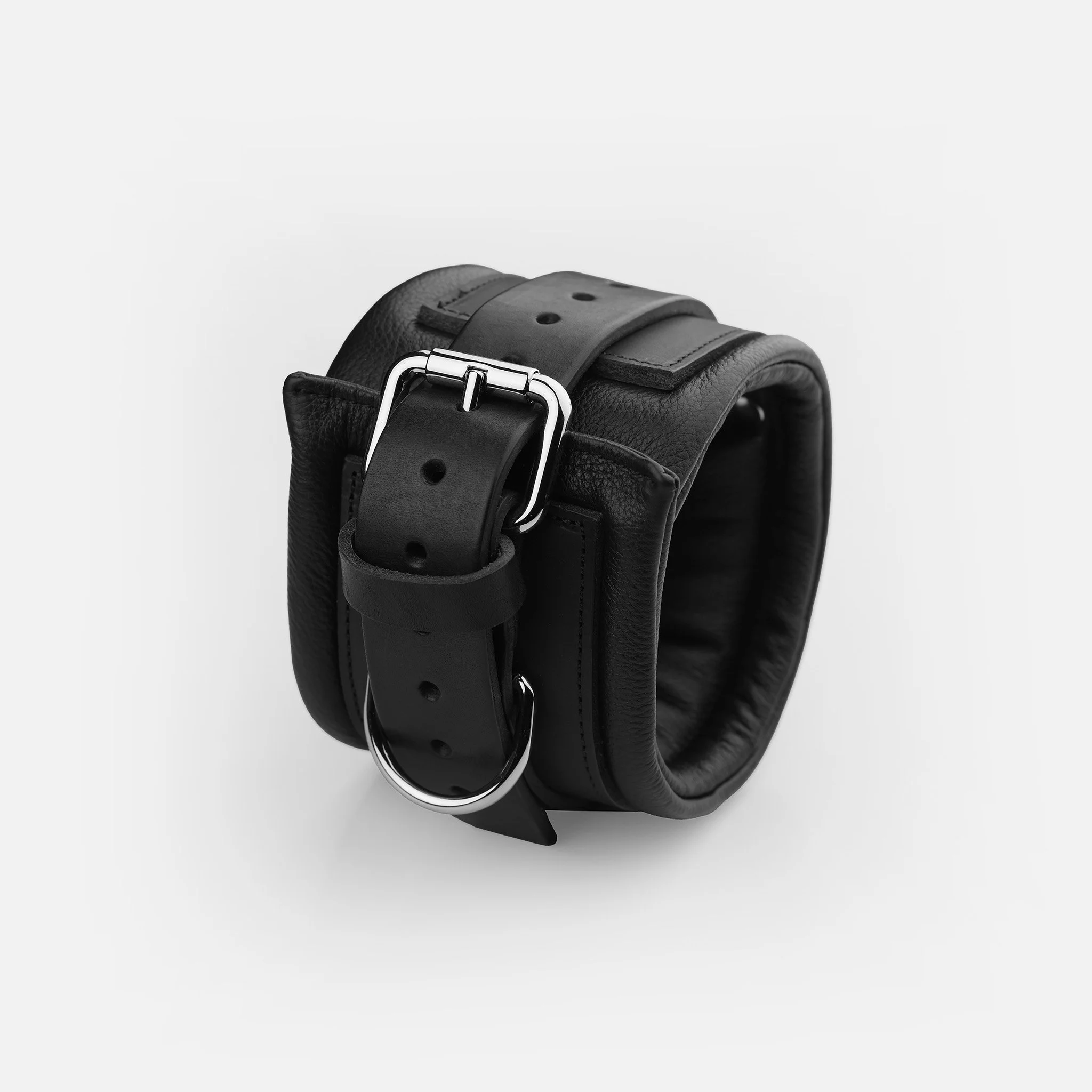 Adjustable roller buckle, multiple holes, and reinforced D-rings on premium black leather ankle cuffs