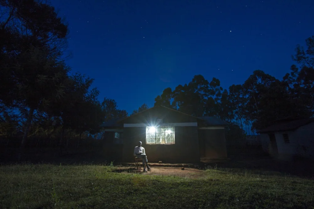 A picture of one of someone using the solar power provided by one of FSM's eventual Impact Investments, M-KOPA.