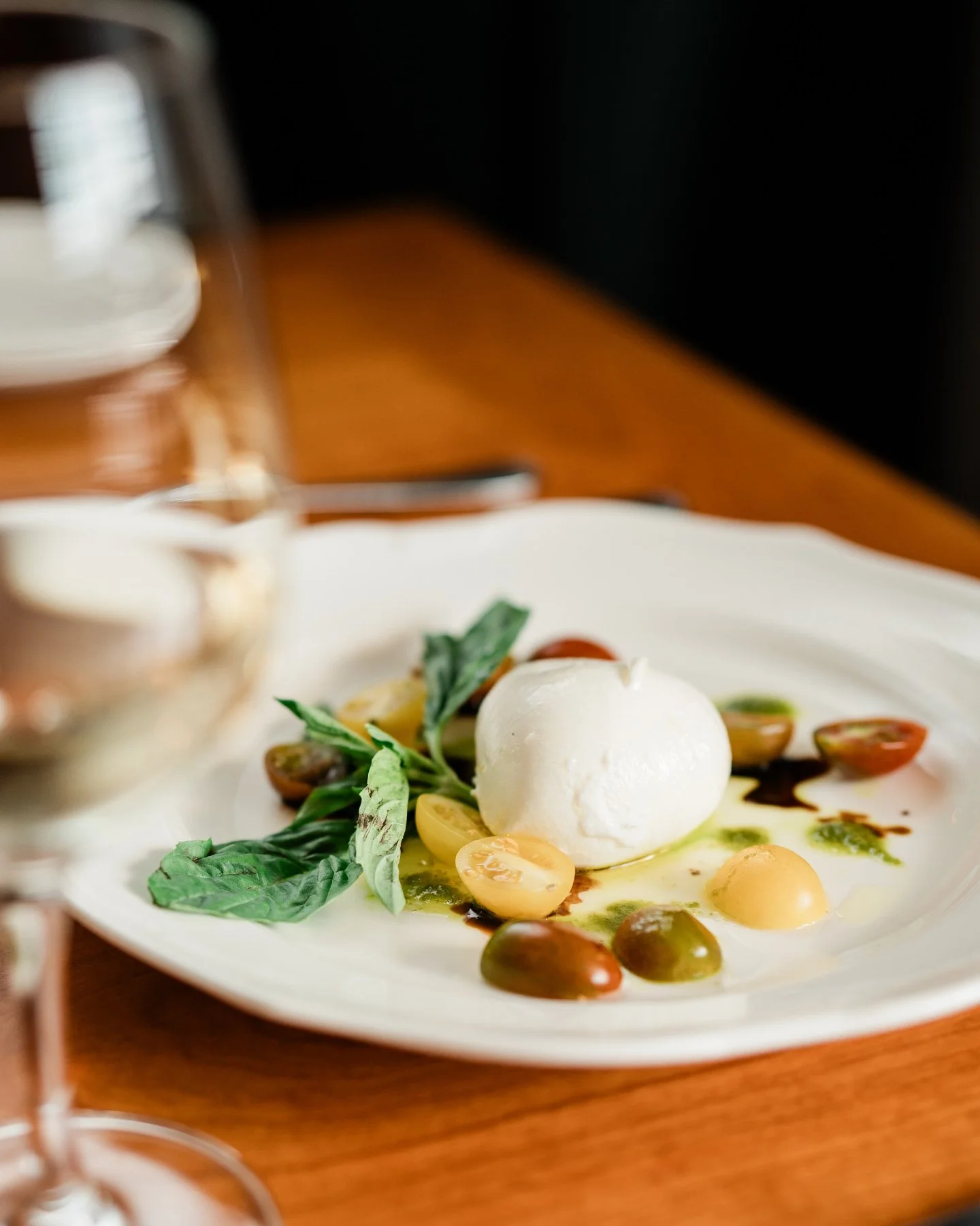 Burrata has a way of making a plate feel complete before anything else is added.

ViBo's is DOP &mdash; brought in from Puglia &mdash; set alongside vine ripened tomatoes and finished with a pesto extra virgin olive oil from the same region. Nothing 