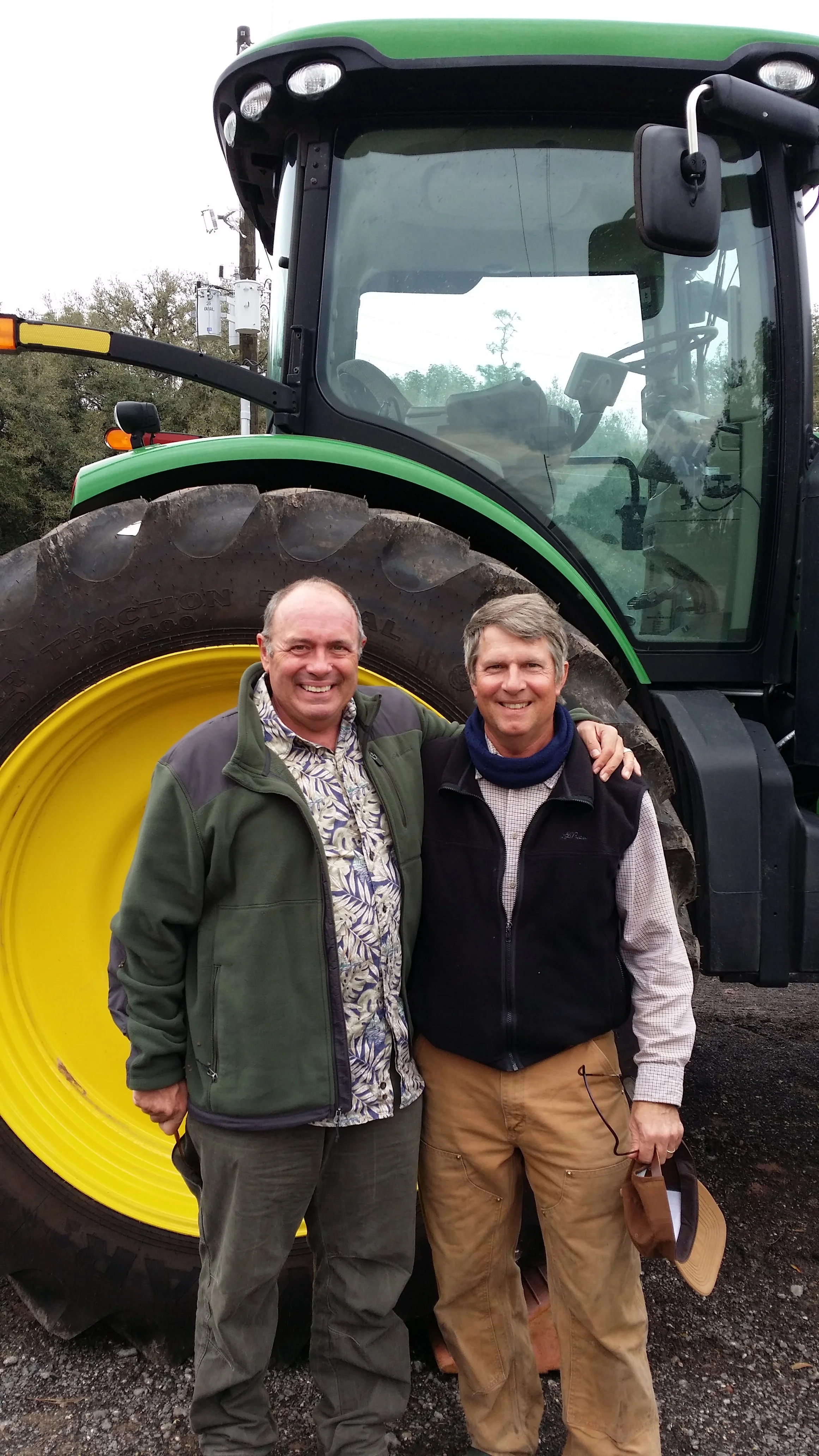 Leonard Park and Birge Sigety in front of a new tractor at the farm.
