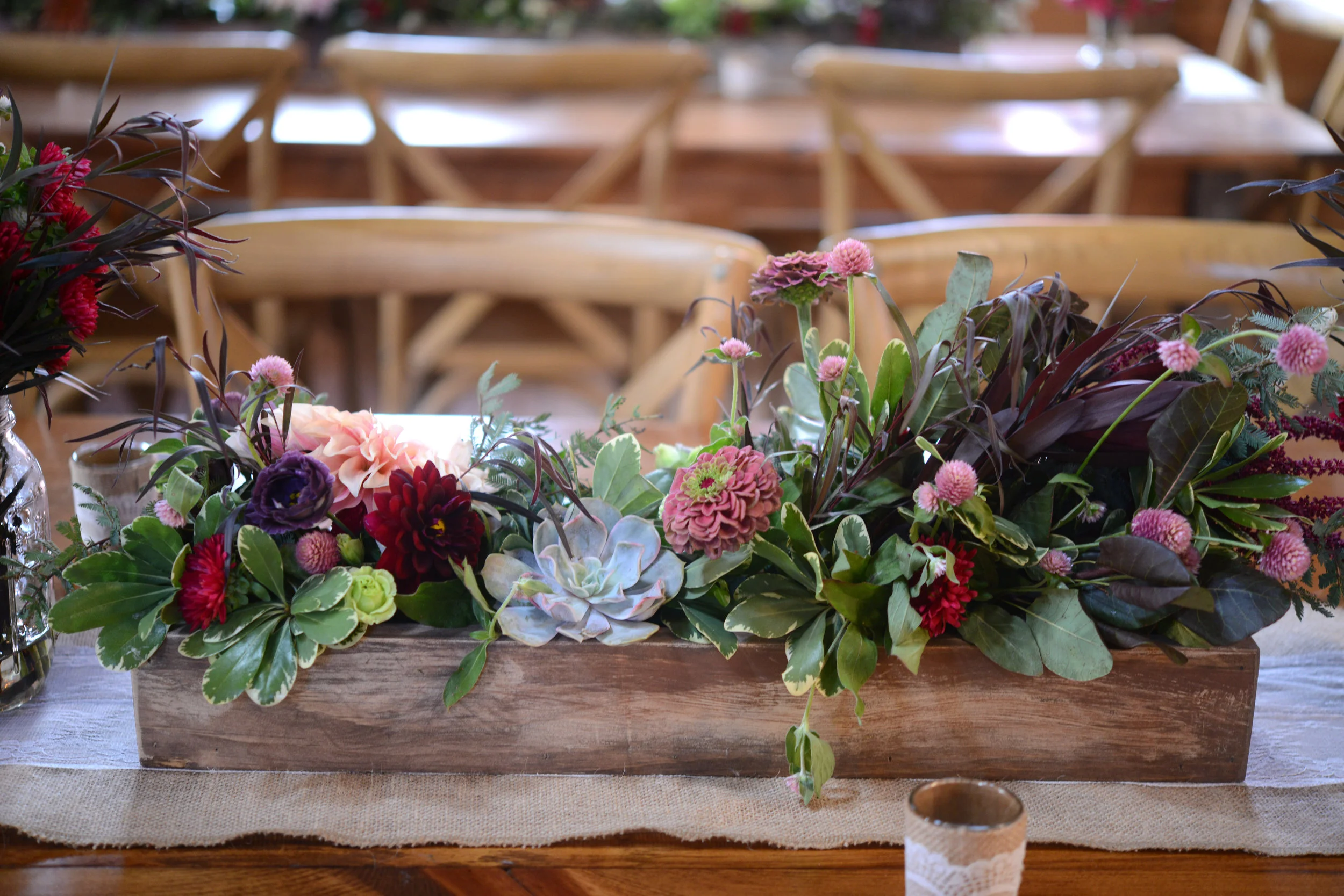 The succulents then worked perfectly in the low and lush, custom-built rustic wood boxes that decorated the long reception tables.
