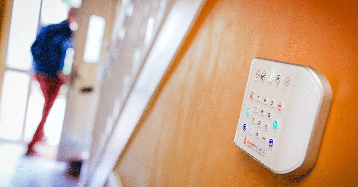 man leaving house alarm system on wall