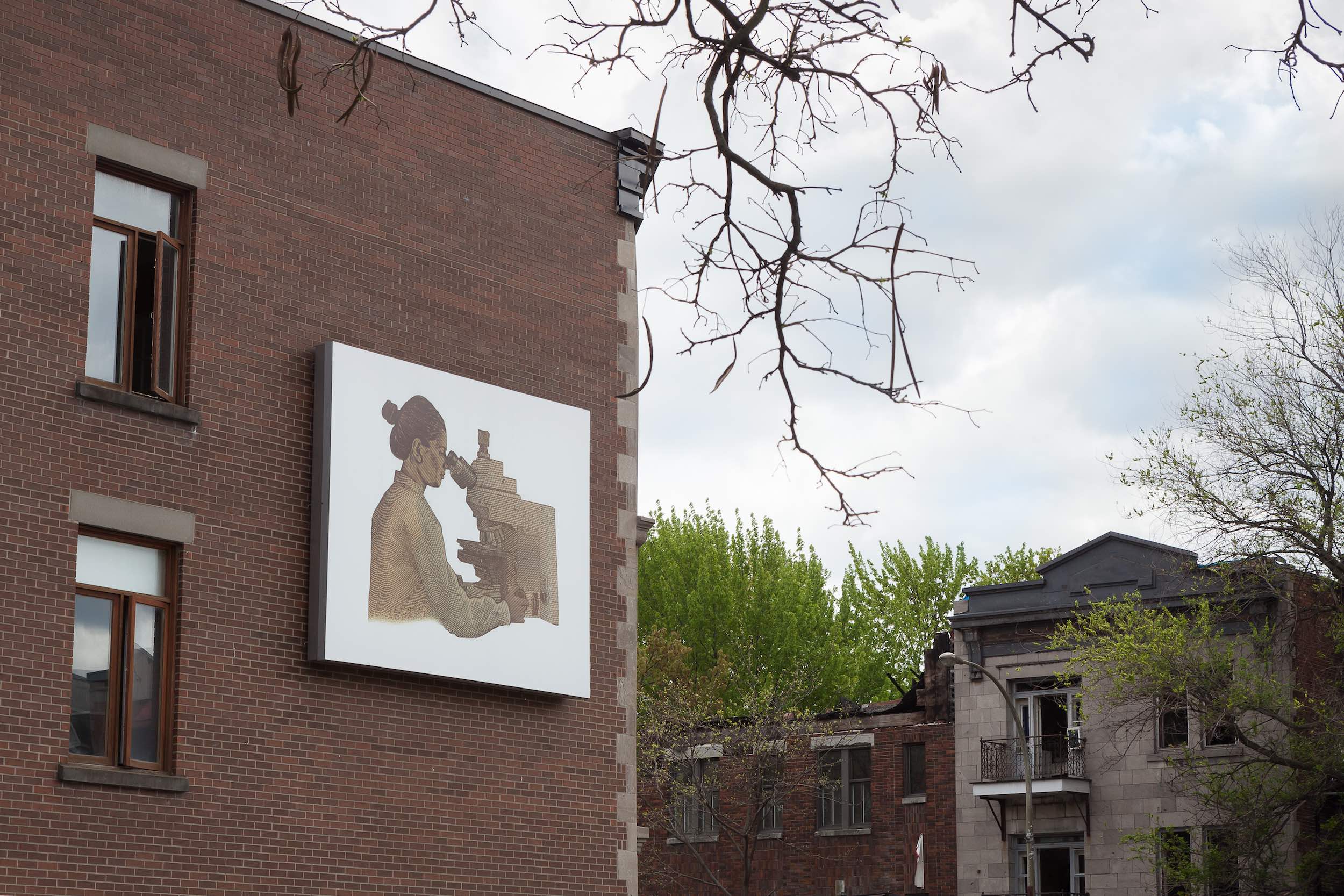  © Life of a Craphead,  $100 Bill With South Asian Scientist Added Back In  (2019). Installation view, Dazibao, 2019. Façade of Café Cherrier. Photo: Marilou Crispin. 