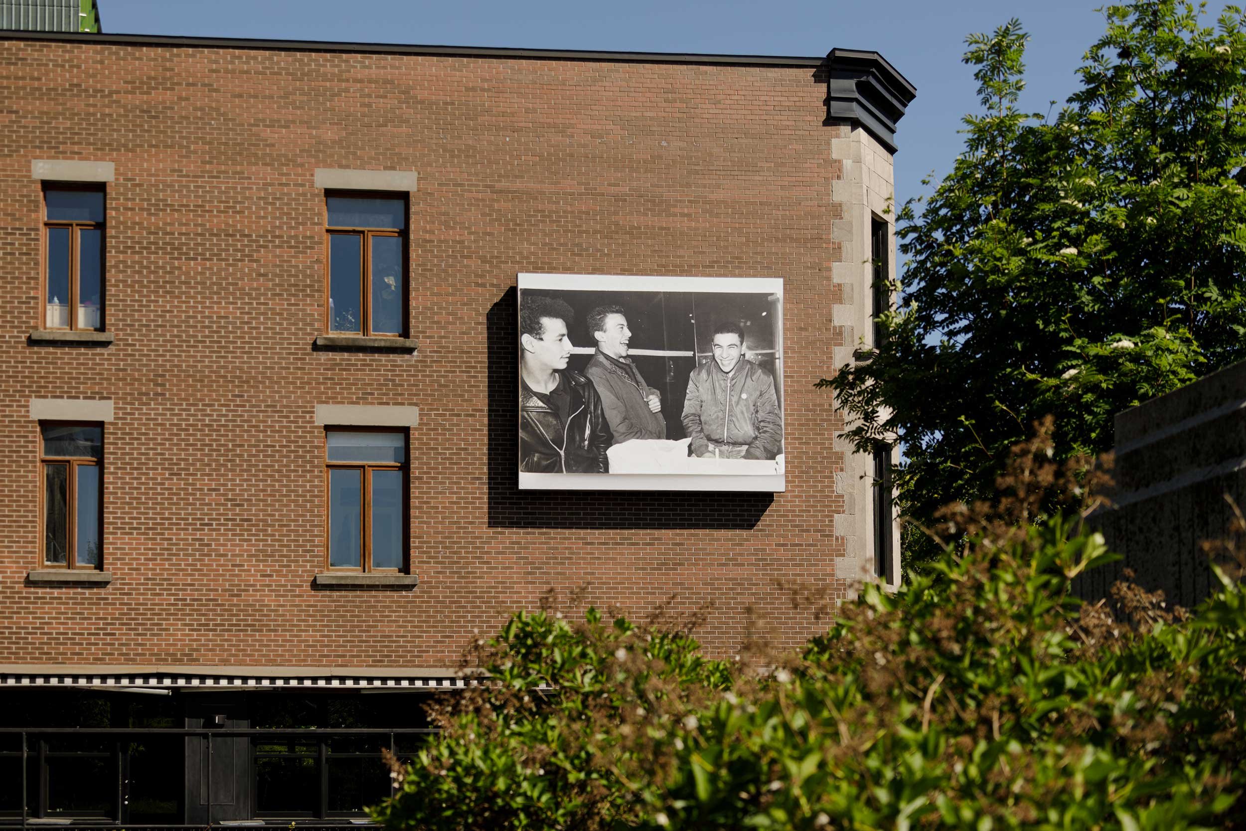  © Abbas Akhavan,  Omay, Djamal, Albert. hiver 1982  (2023). Installation view on the façade of Café Cherrier, Dazibao, 2023. Photo: Document original. 