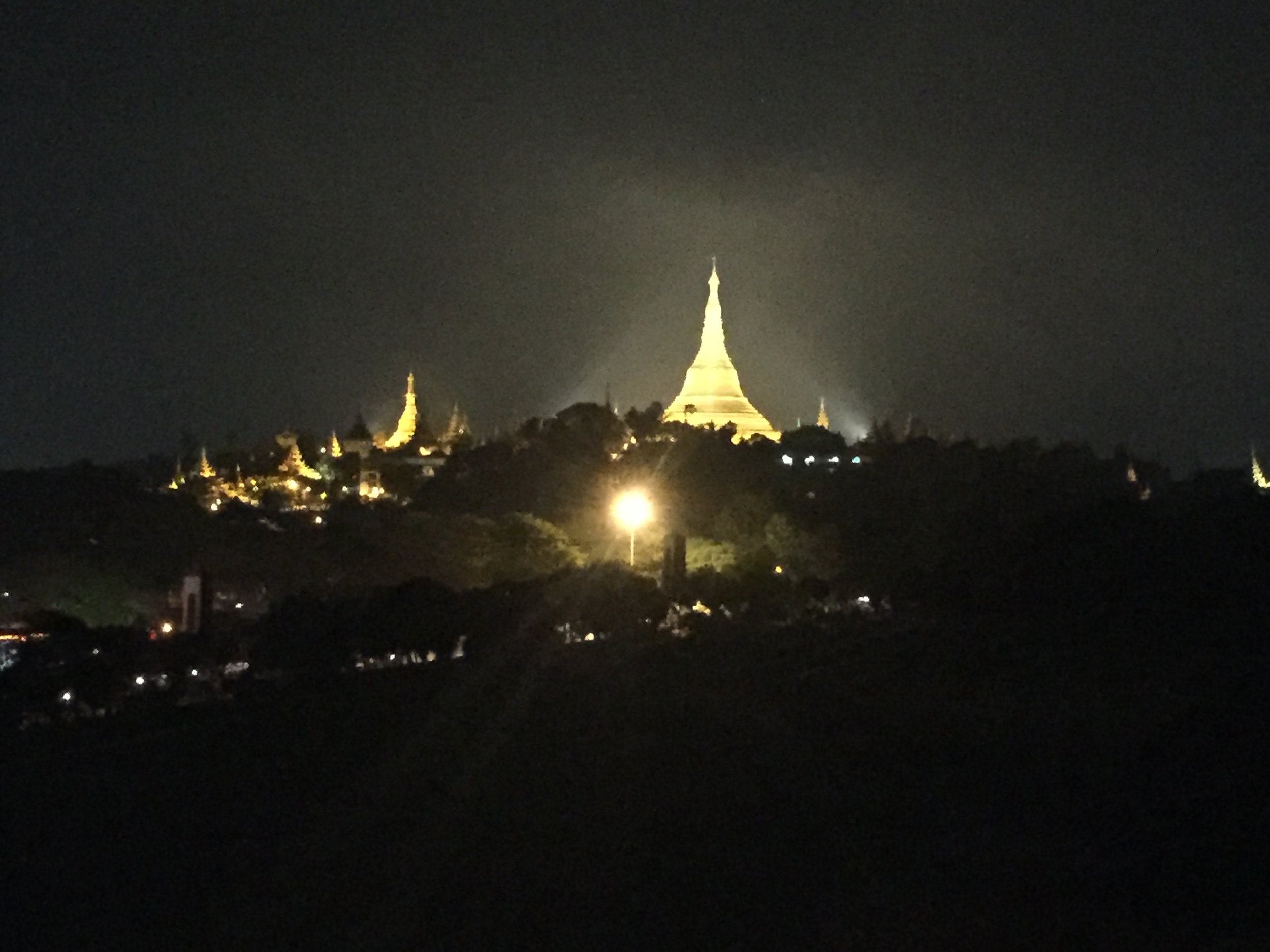 Shwedagon seen from a kilometer away, changing colors through sunset and night.