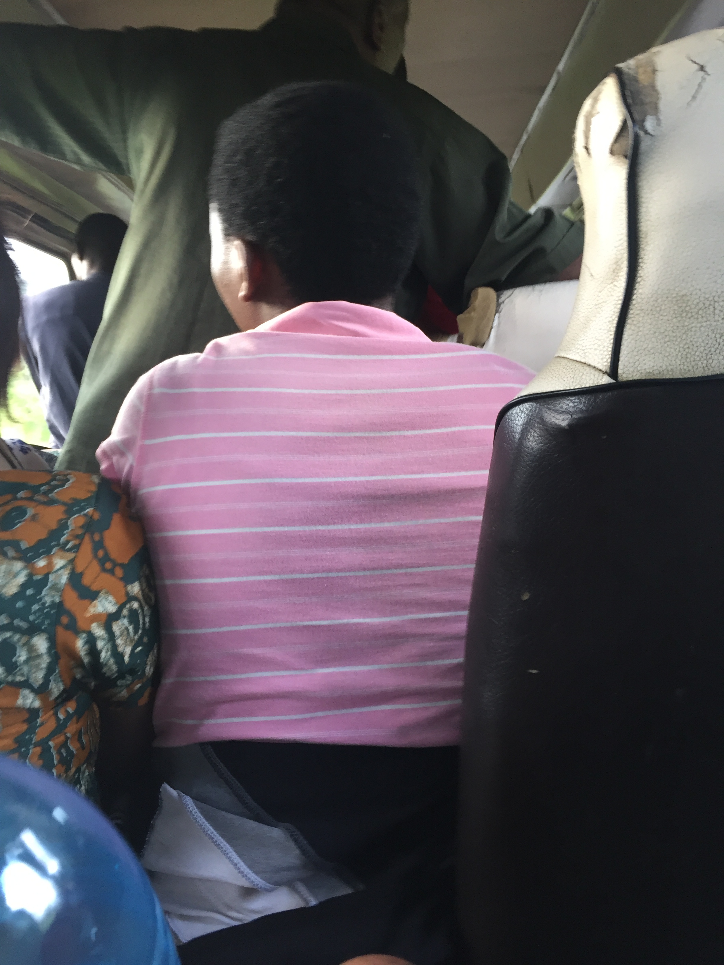 Packed into a dara dara behind a woman sitting between two seats. These minibuses often put buckets down in the aisles to accommodate extra sitting passengers.