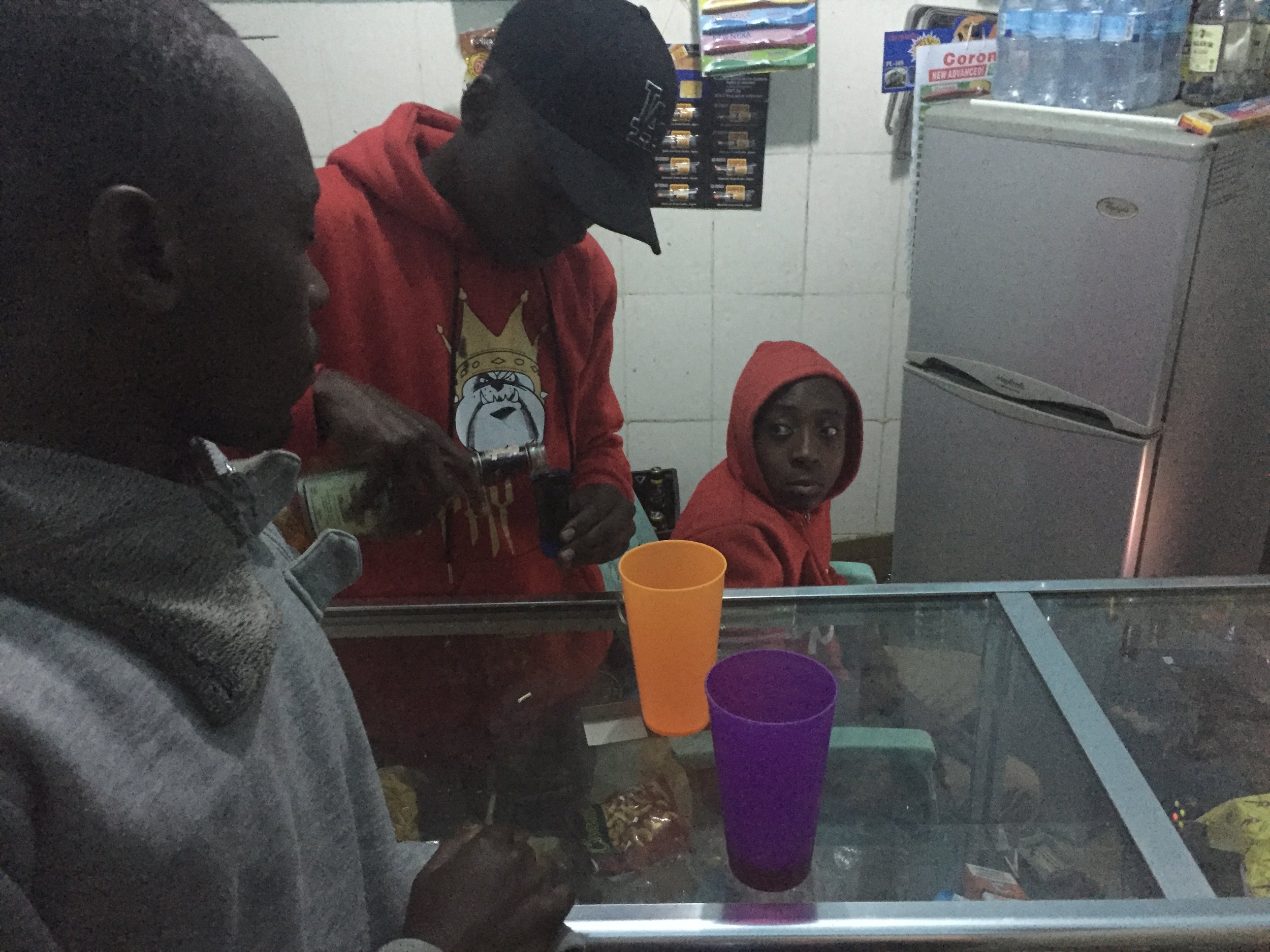 Grabbing a drink from the 'bar' in Gabriel's neighborhood - the front porch of a man's house where he put a stand and fridge.