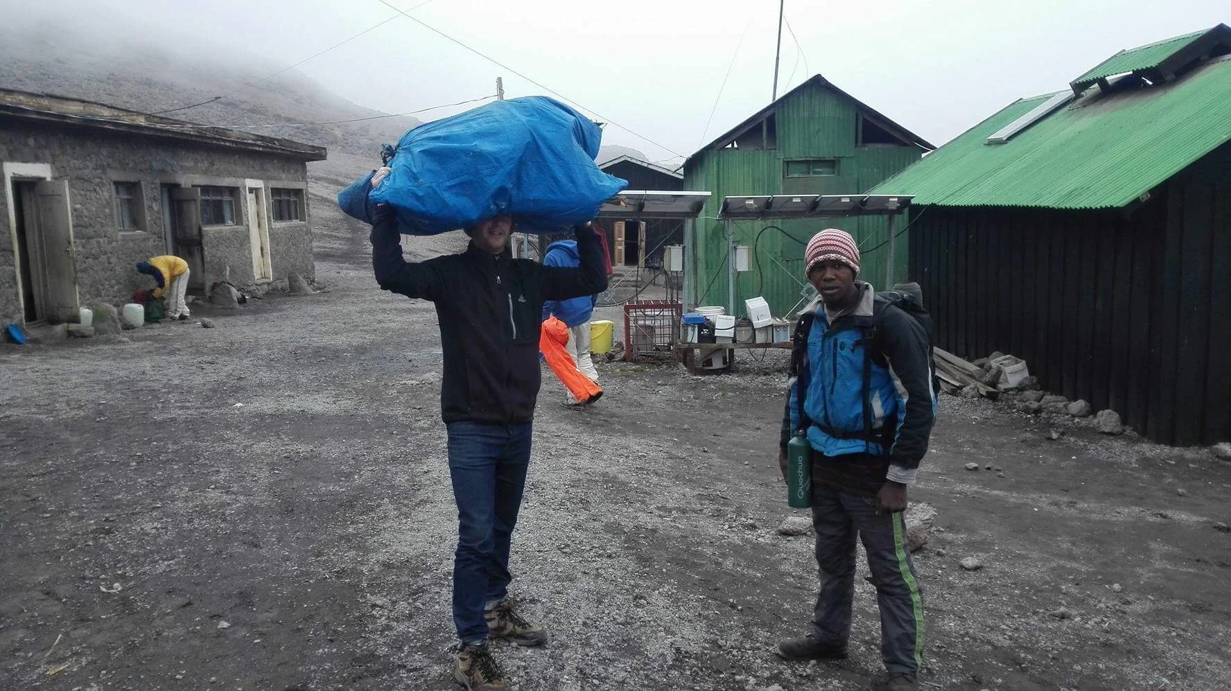 "Muzungu porter," lifting the heavy load that porters carry up the mountain on their heads.