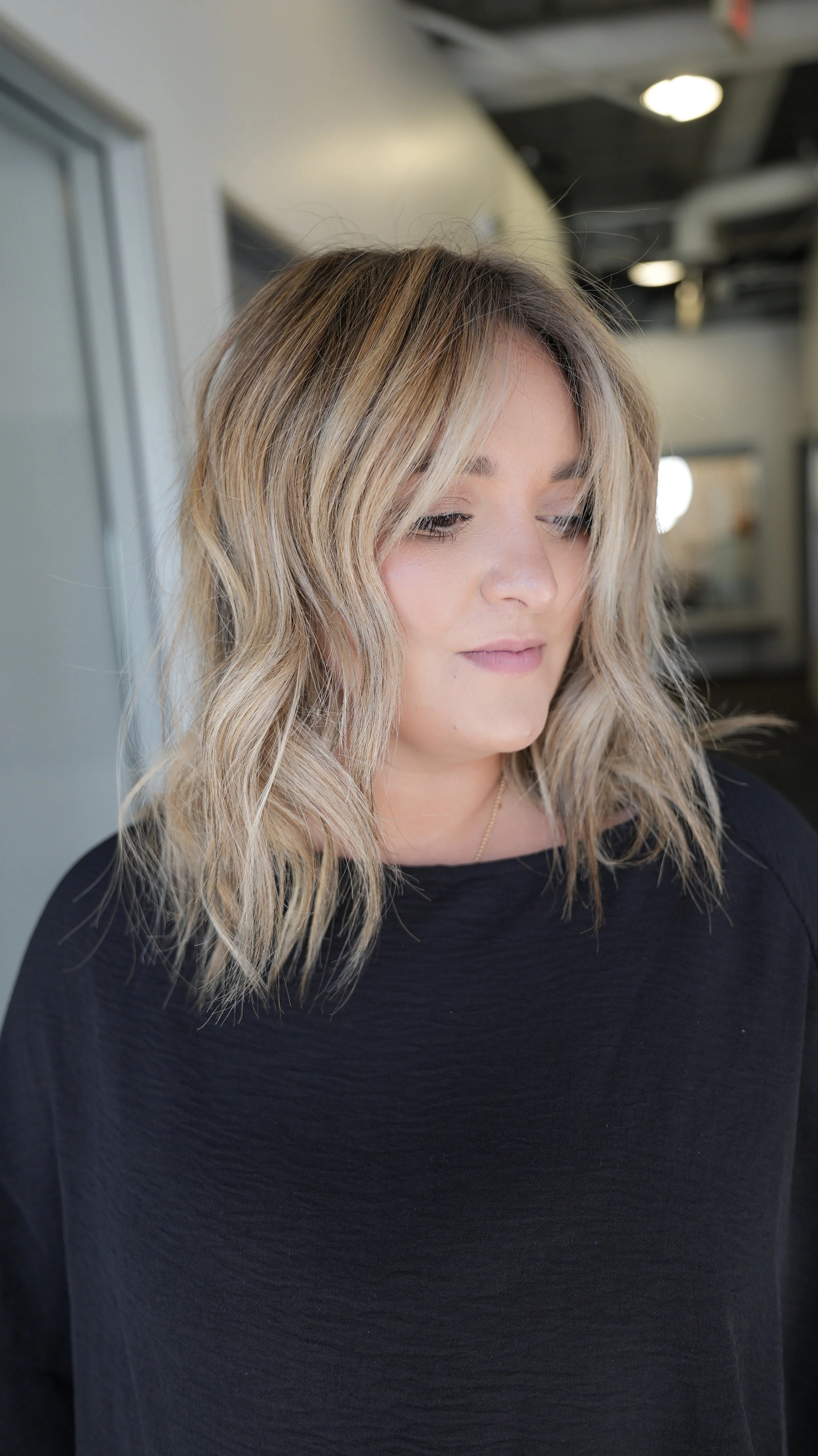 “Brunette hair with a shadow root blending into blonde highlights through the lengths.”