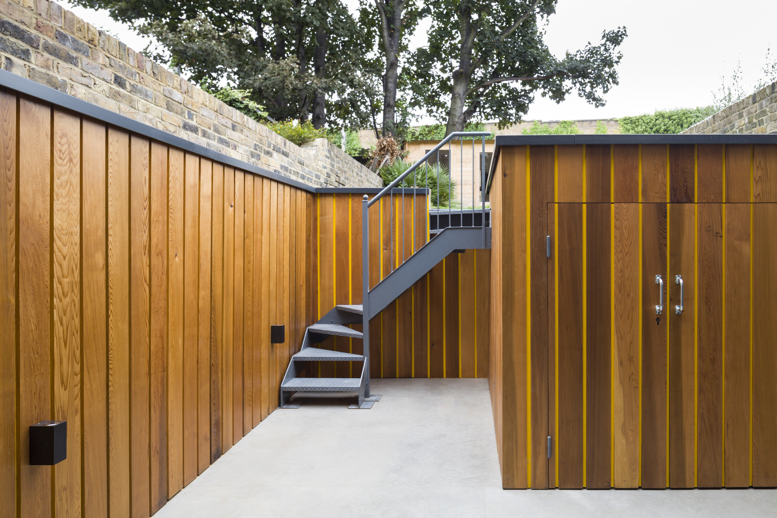 The design provides dedicated secure cycle storage in the courtyard which is clad in a stripy cedar and metal strips.