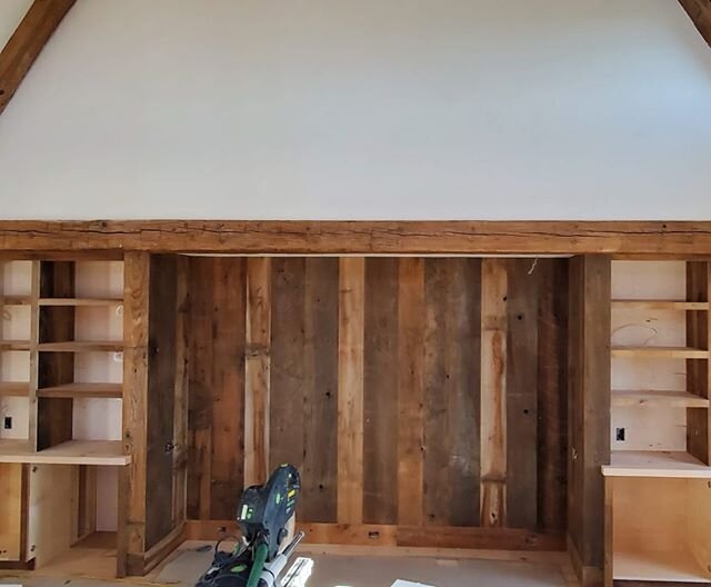 Reclaimed beams and barn boards with flanking custom cabinets.