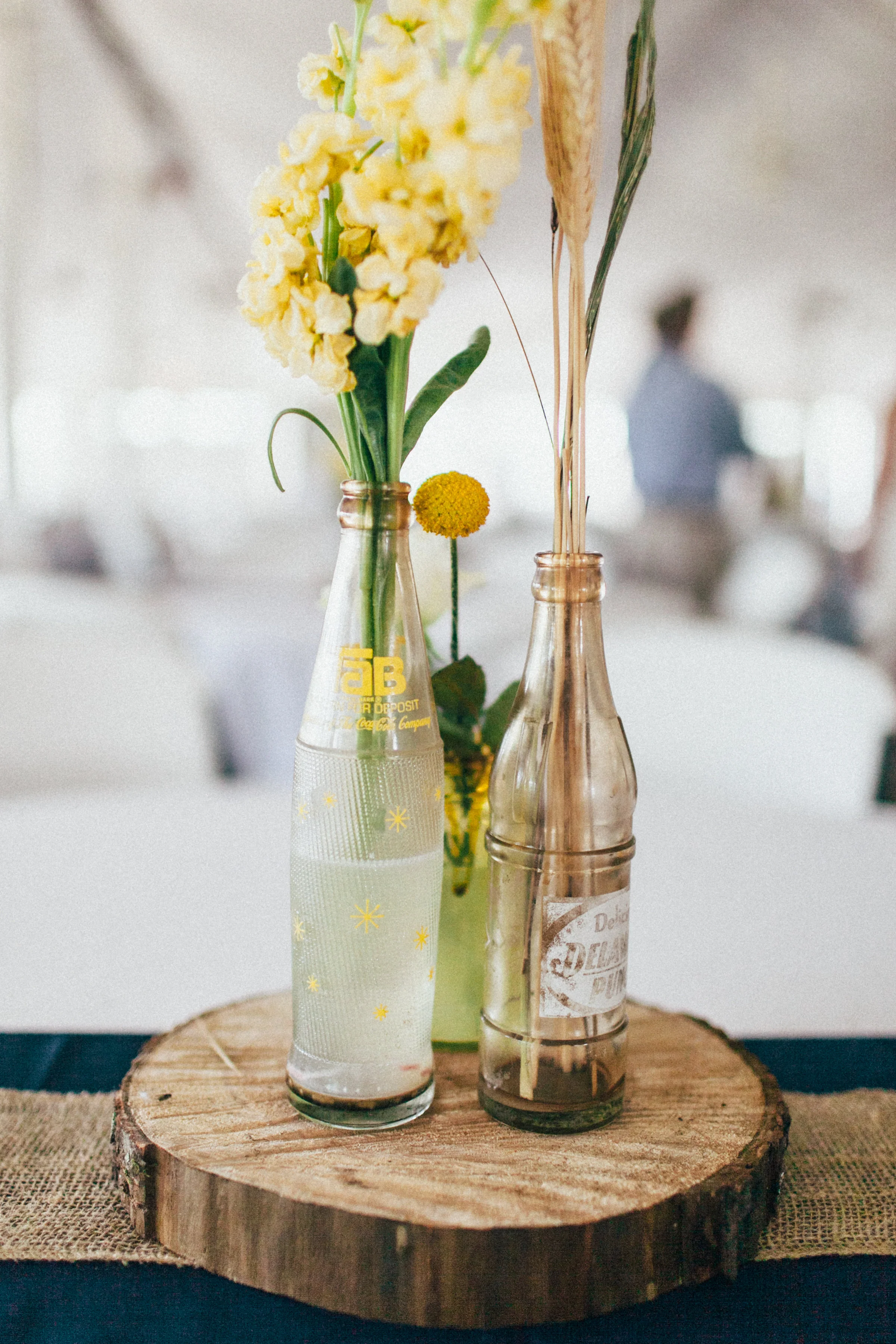 Nicole and her mother cleverly baked bottles in an oven to give them a vintage appearance. These darling accents were fashioned into fitting centerpieces for each table and were filled with wheat, cotton, and other simple flowers.