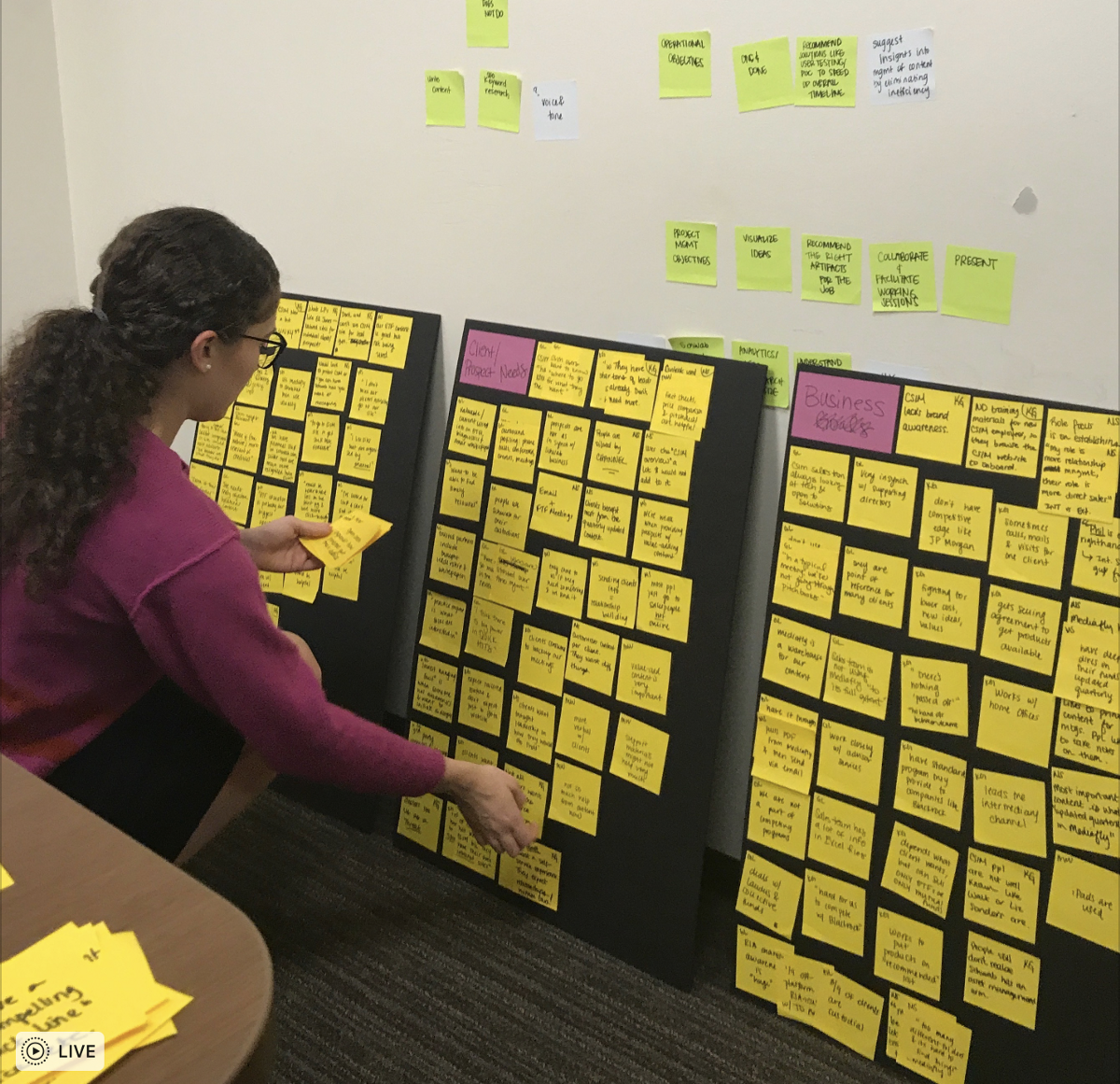 My old team mate, Luna, sorting through user interview insights on sticky notes.
