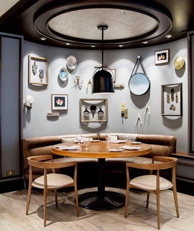 GONE CRUISING:: Here's a quiet little corner at SHARE by @curtisstone, aboard @princesscruises. The space was designed by Jeffrey Beers, a renowned New York interior designer. They share (see what we did there?), "A signature feature of SHARE is a communal table designed to encourage the sharing of a freshly prepared meal in the company of friends and family and illuminated by hand blown glass pendants etched with inspiring phrases casting an intimate glow and creating a warm and welcoming experience. Elements not often seen in cruise ship restaurant interiors add to the comfortable atmosphere – low-backed banquettes, beautifully upholstered in luxe Chesterfield tufted leather and decorative curios from Chef Stone’s own collection." 📷 @jeffreybeersinternational⠀
.⠀
.⠀
.⠀
.⠀
.⠀
.⠀
#JBICreation #CurtisStone #PrincessCruises #restaurant #restaurantdesign #cruiseship #cruiseshipdesign #cuisine #dining #decor #design #interiordesign #comebacknew #cruising #design #shipdesign #newyork #interiordesigner #interiordesign #leather #banquette #blogger #travelblogger #hotelblogger #designtravelcruise