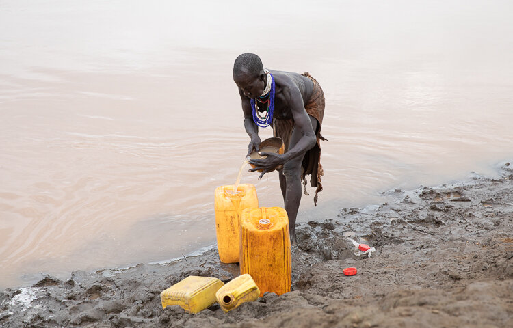 african tribe woman collecting water in karo tribe Omo Valley ethiopia 