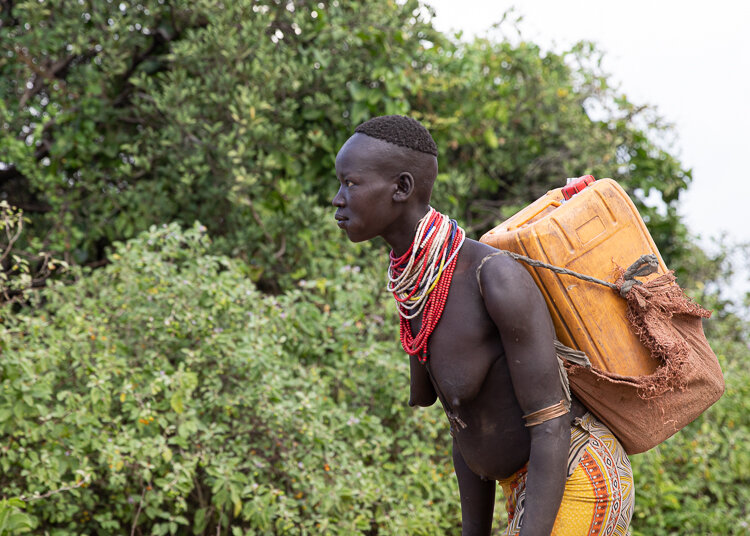 ethiopia karo tribe carrying water back to karo village