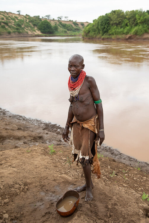 ethiopia Omo Valley karo tribe woman collecting water from Omo River