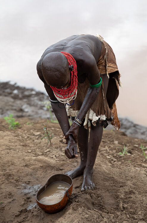 ethiopia Omo Valley Kara tribe woman washing in river