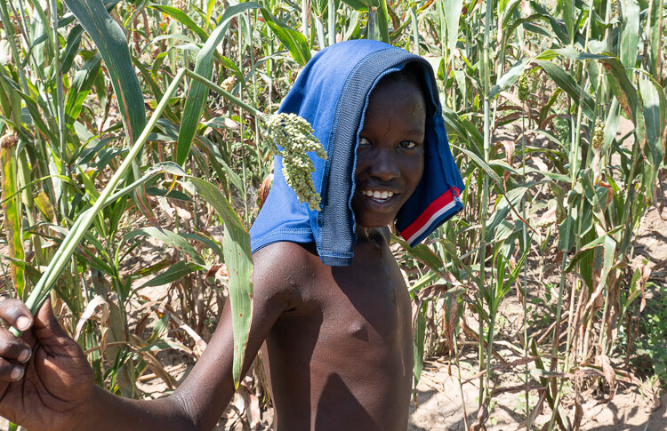 A young boy walks with us through their farmland