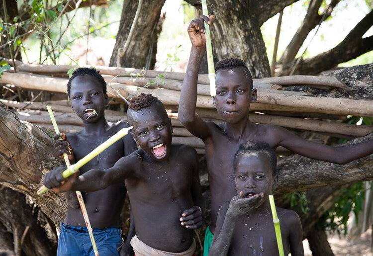Ethiopia Omo Valley tribe boys with sugar cane and cheeky smiles