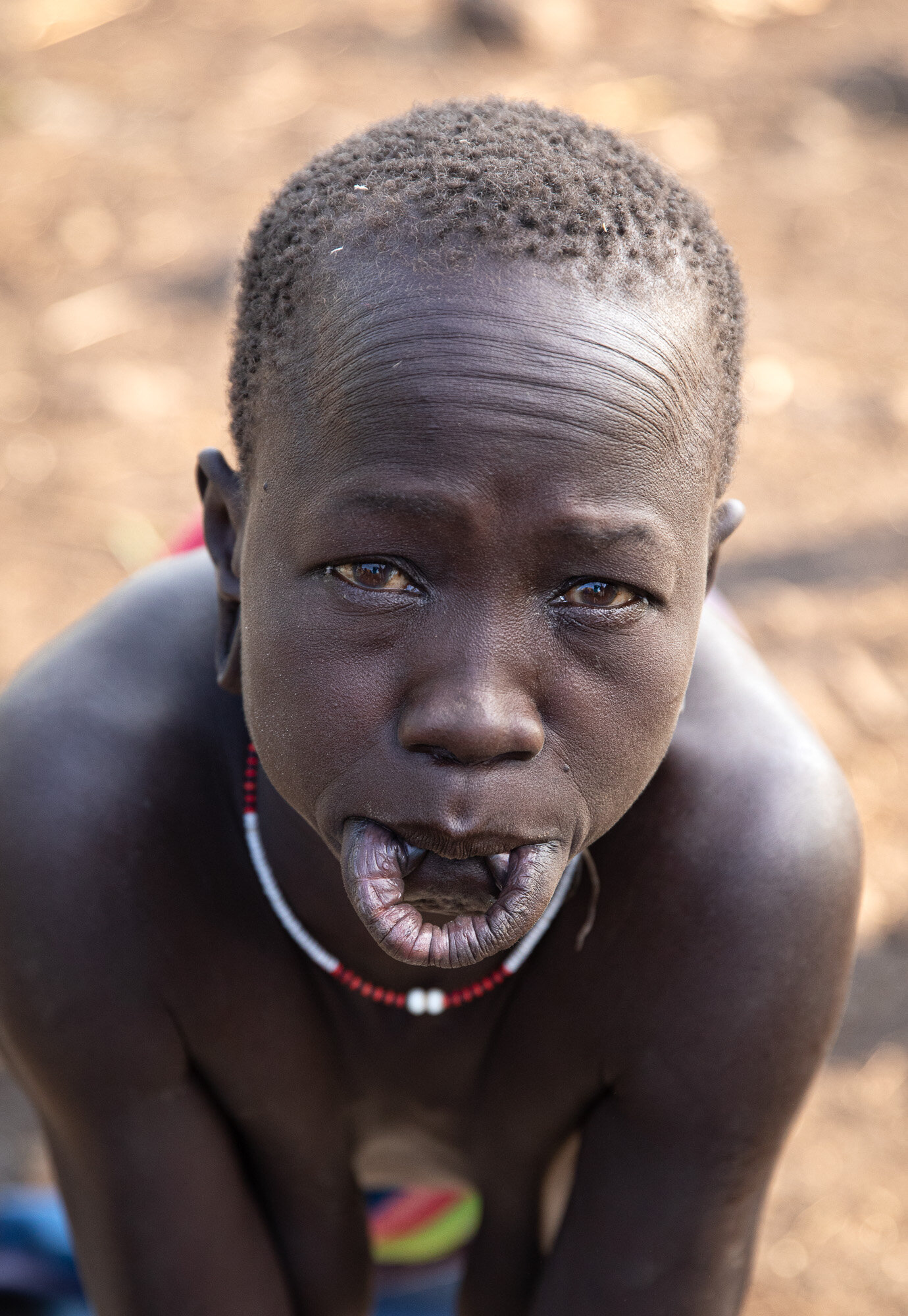 Surma tribe lip plate woman looking up Ethiopia 