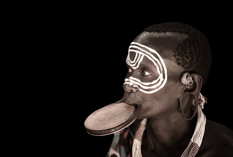 Suri Tribe woman portrait close up with lip plate and body paint