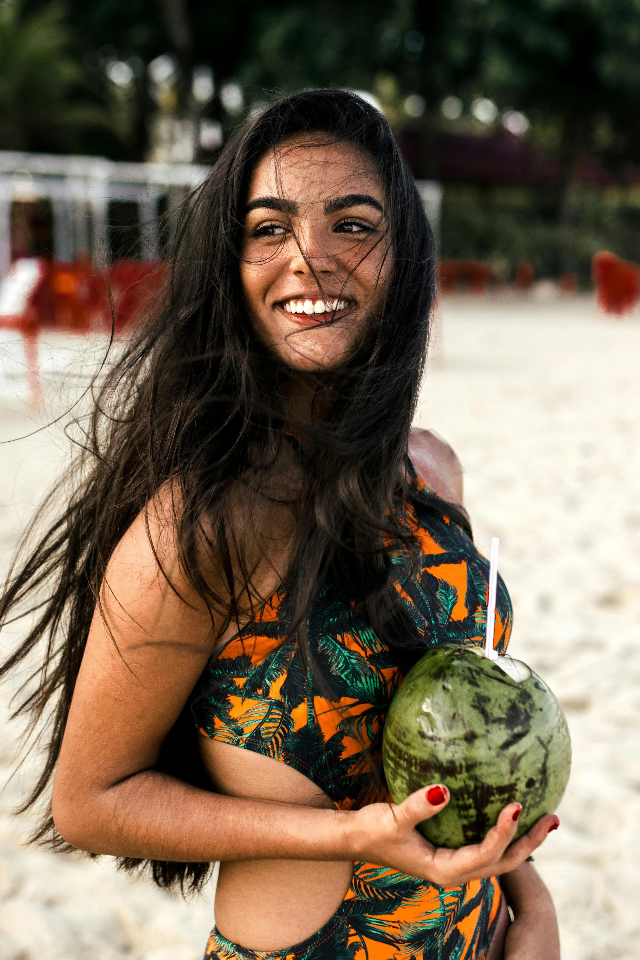 Beachside inspo photo of long, healthy-looking hair with natural movement, similar to the results of hand-tied extensions offered at Cosmic Beauty