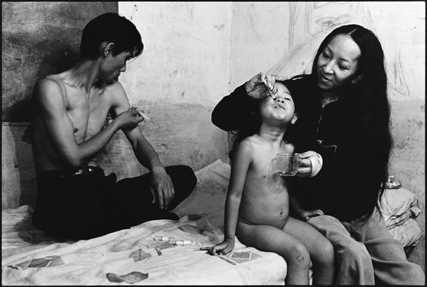 A Father Injecting Heroin and a Mother Feeding Her Daughter Heroin