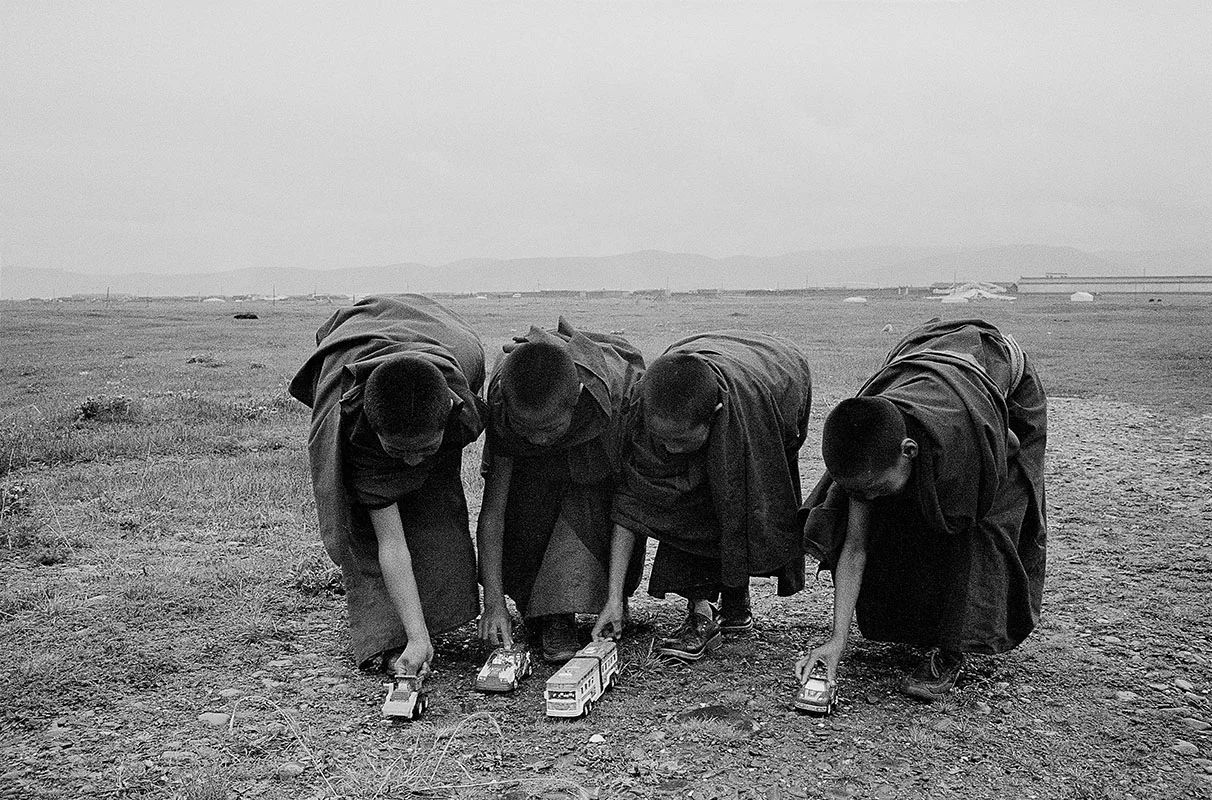 Four young monks playing with toy cars, Sichuan