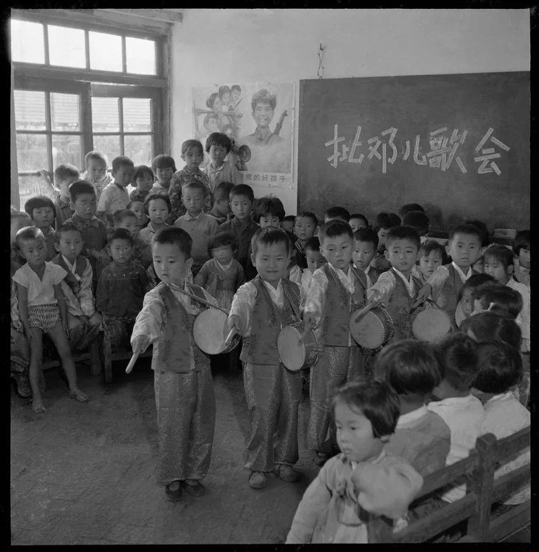 Children playing drums to show revolutionary determination.