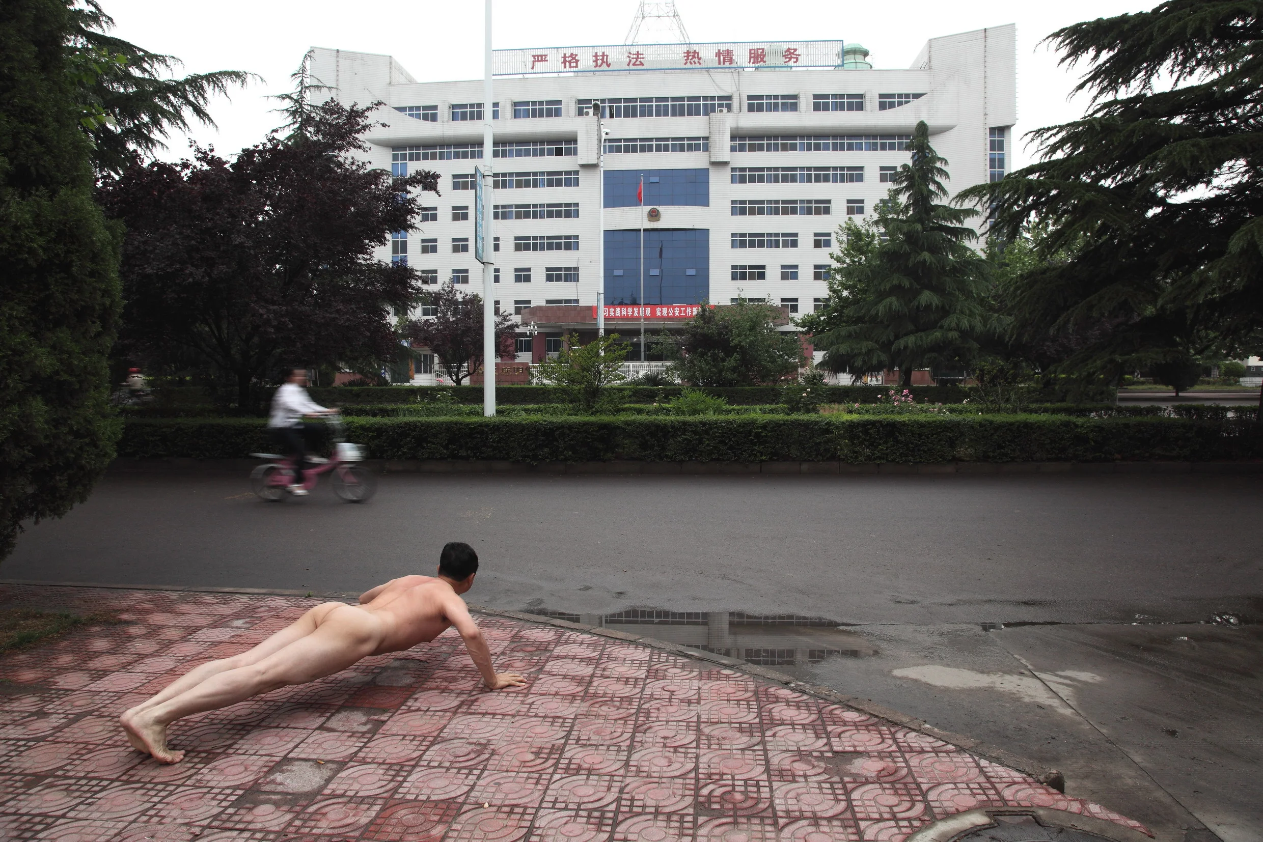 Ou Zhihang Ou Zhihang's practice incorporates a mixture of performance and photography. He does "Ou-style push-ups" in front of many national monuments, on city streets, and at natural sites. He has extended this gesture through two photographic series, "Seen and Be Seen" and "The Moment," which won an Honorable Mention at the World Press Photo Awards in 2009. His nudity represents the vulnerability of the lone individual; his nakedness is surprising, and it is his way of calling attention to places and events of social importance, landscapes that seem innocuous unless you know the reason for the artist's presence.