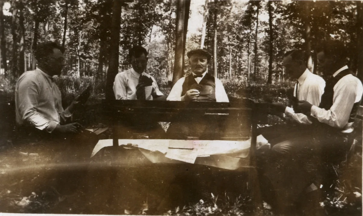 Peter Henry Ratz (center) playing cards with some men in the woods