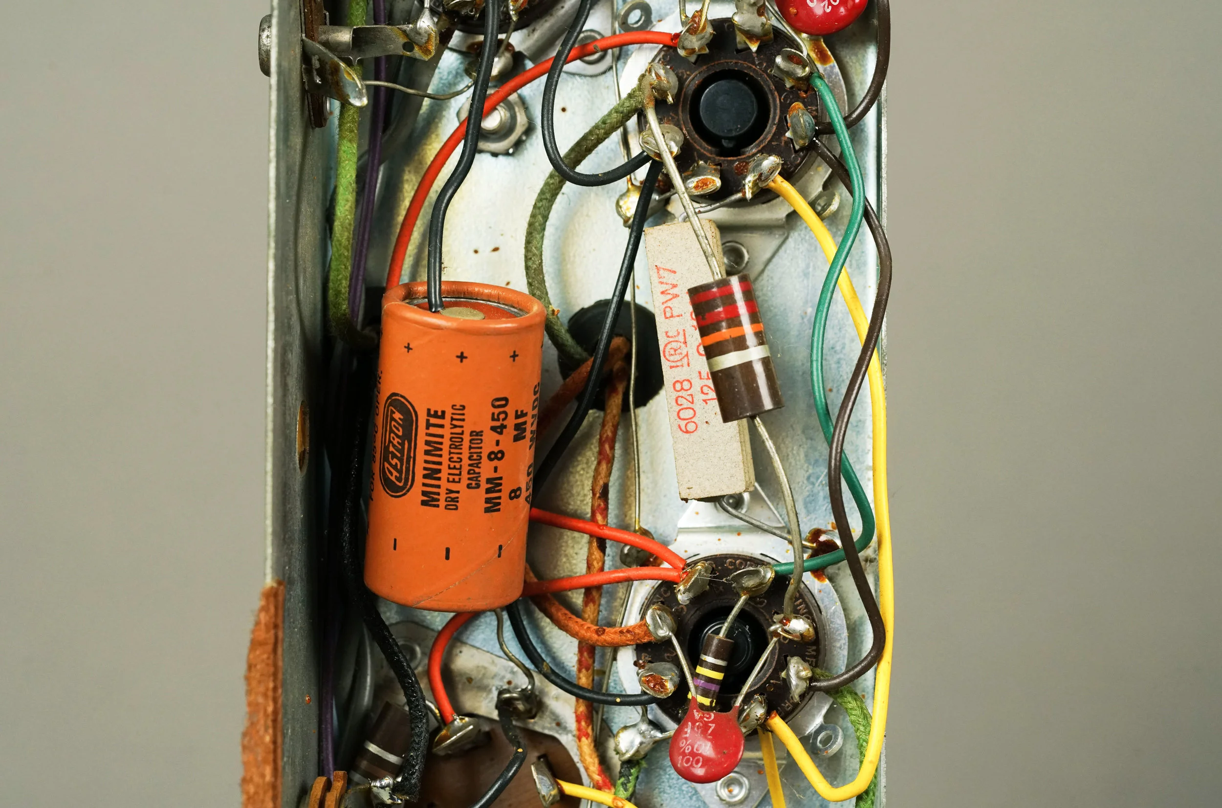 Note the Astron Minimite electrolytic capacitor in this original Wurlitzer 700 amplifier. The leads are very long, which is convenient for mounting in a point-to-point circuit like this one. On the right, there is a 7 watt wirewound resistor as well as a high-wattage (probably 2 watts) carbon composition resistor.