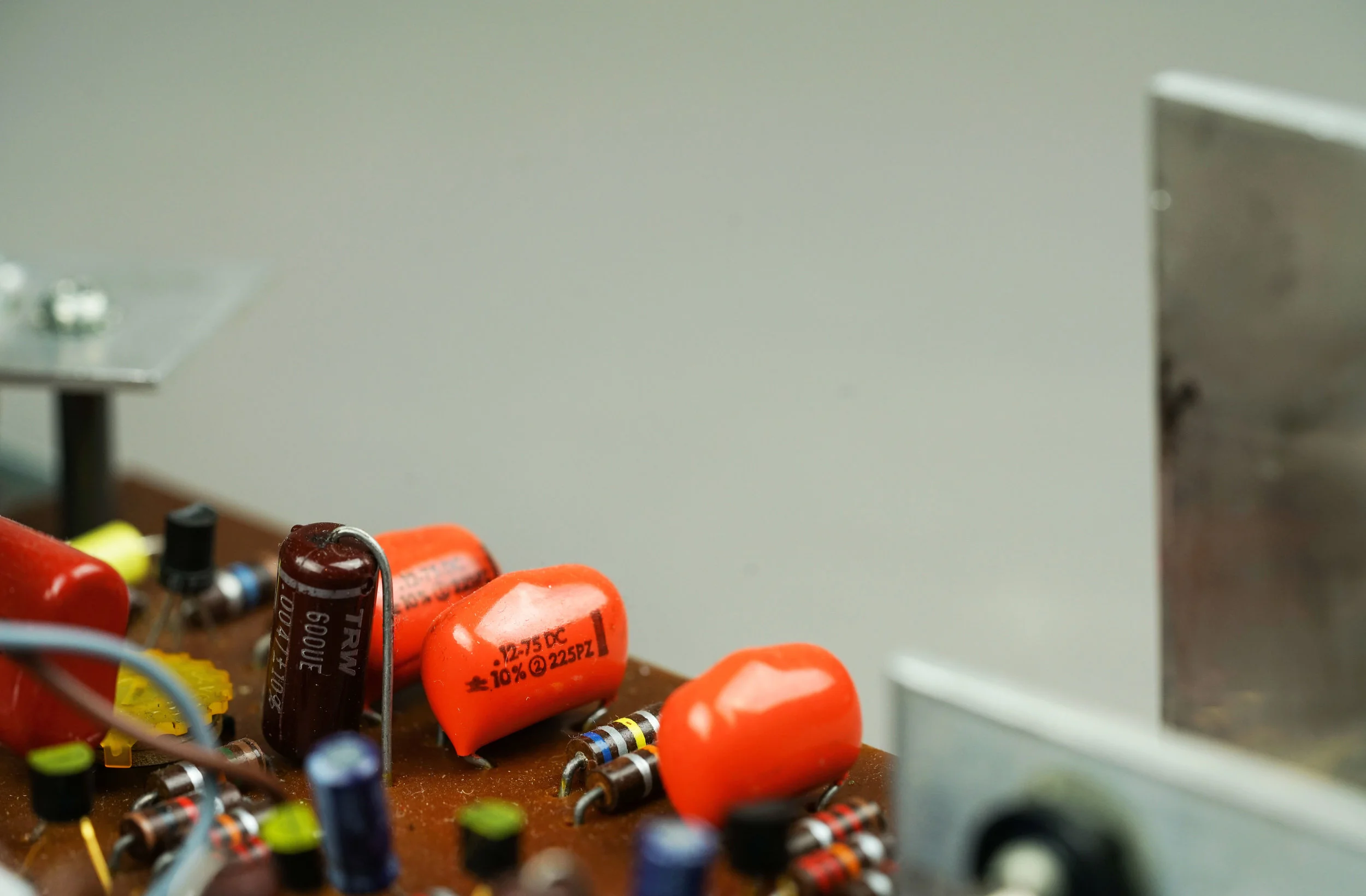 The orange capacitors are the tremolo capacitors in a Wurlitzer 200. They provide the phase shift that allows the circuit to oscillate.