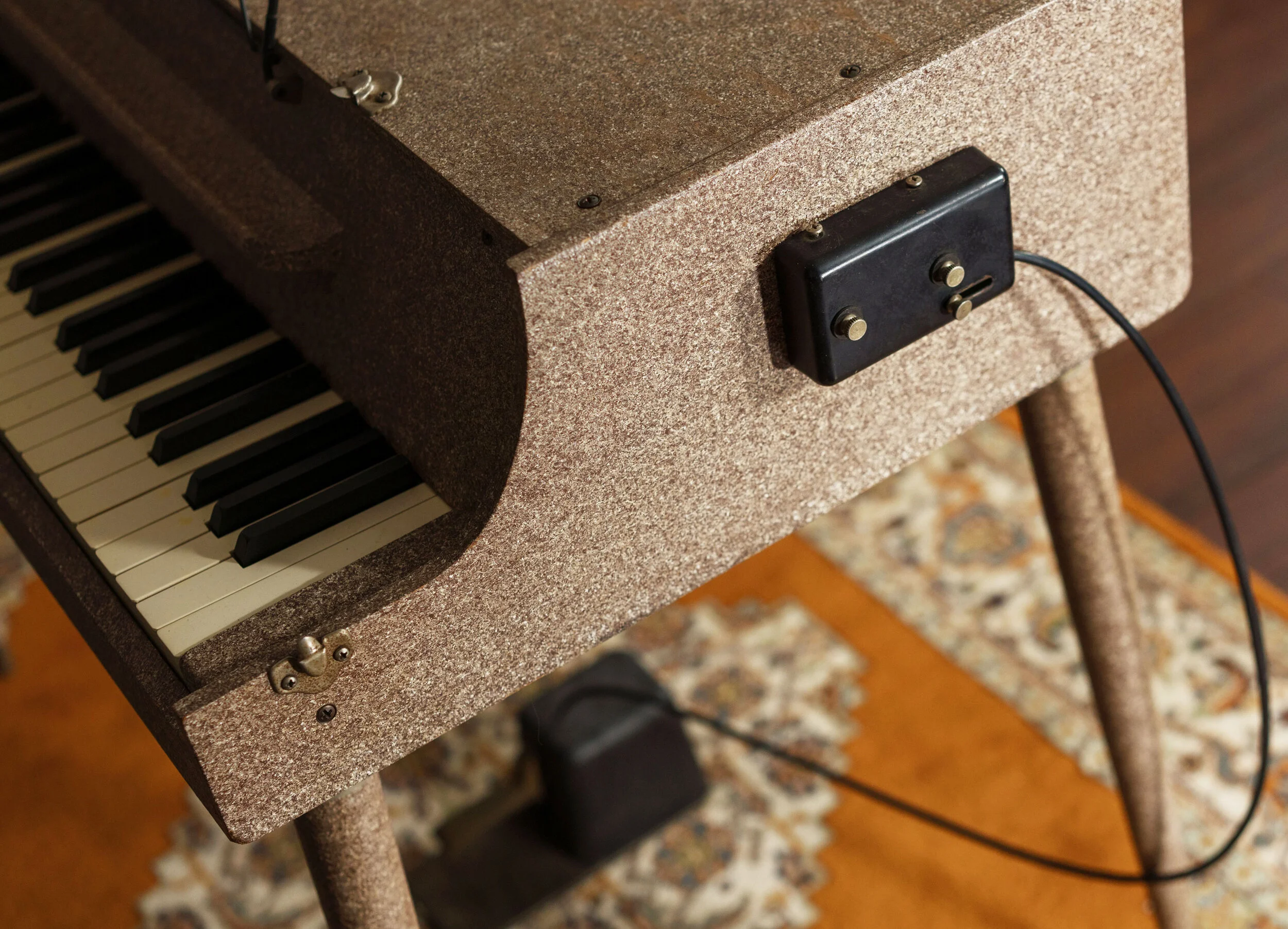 A closeup of the Wurlitzer 112 showing how the sustain pedal connects to the side of the case.