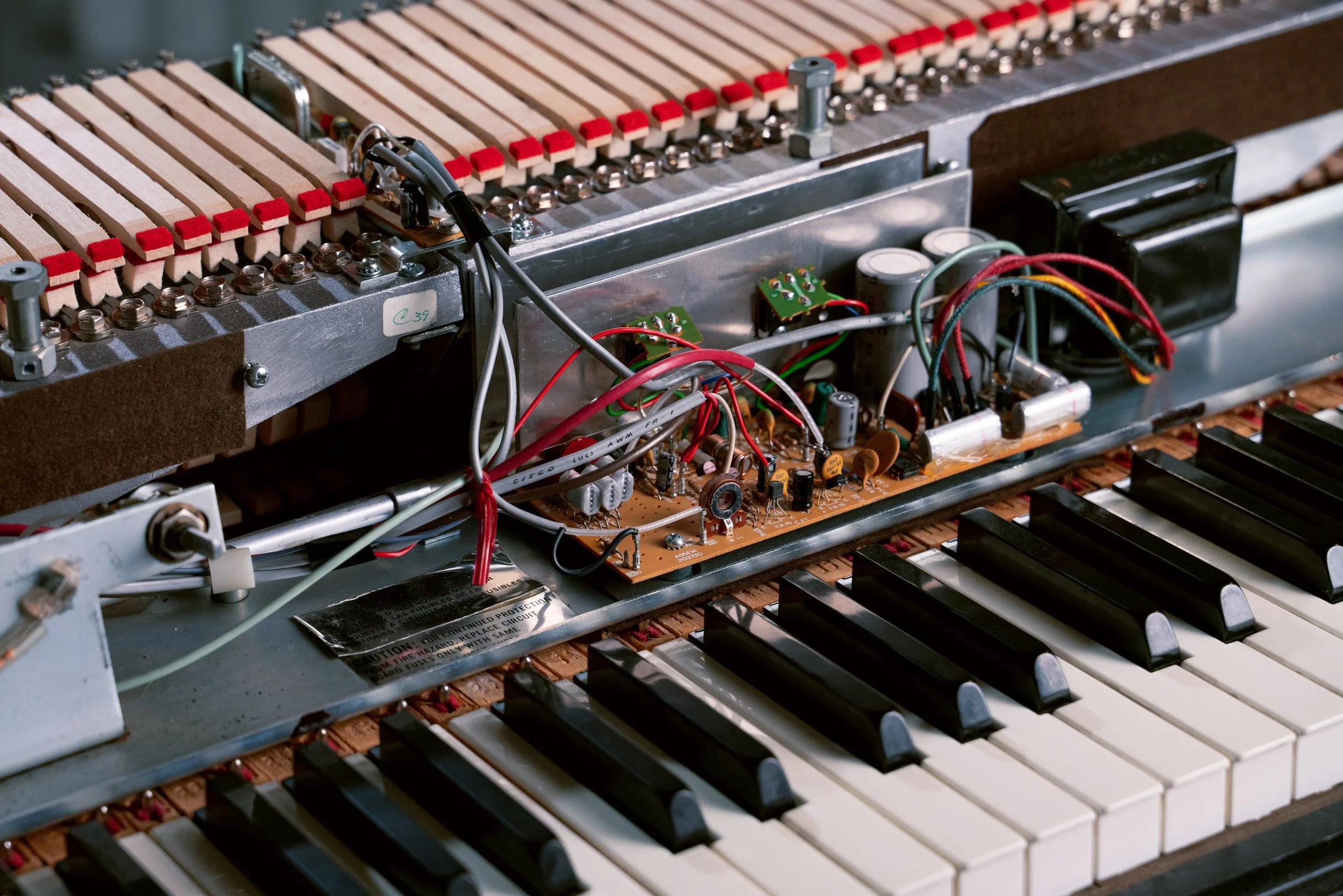 A closeup of a 200A amplifier mounted in the keyboard, showing the wiring arrangement and some of the keys in the foreground.
