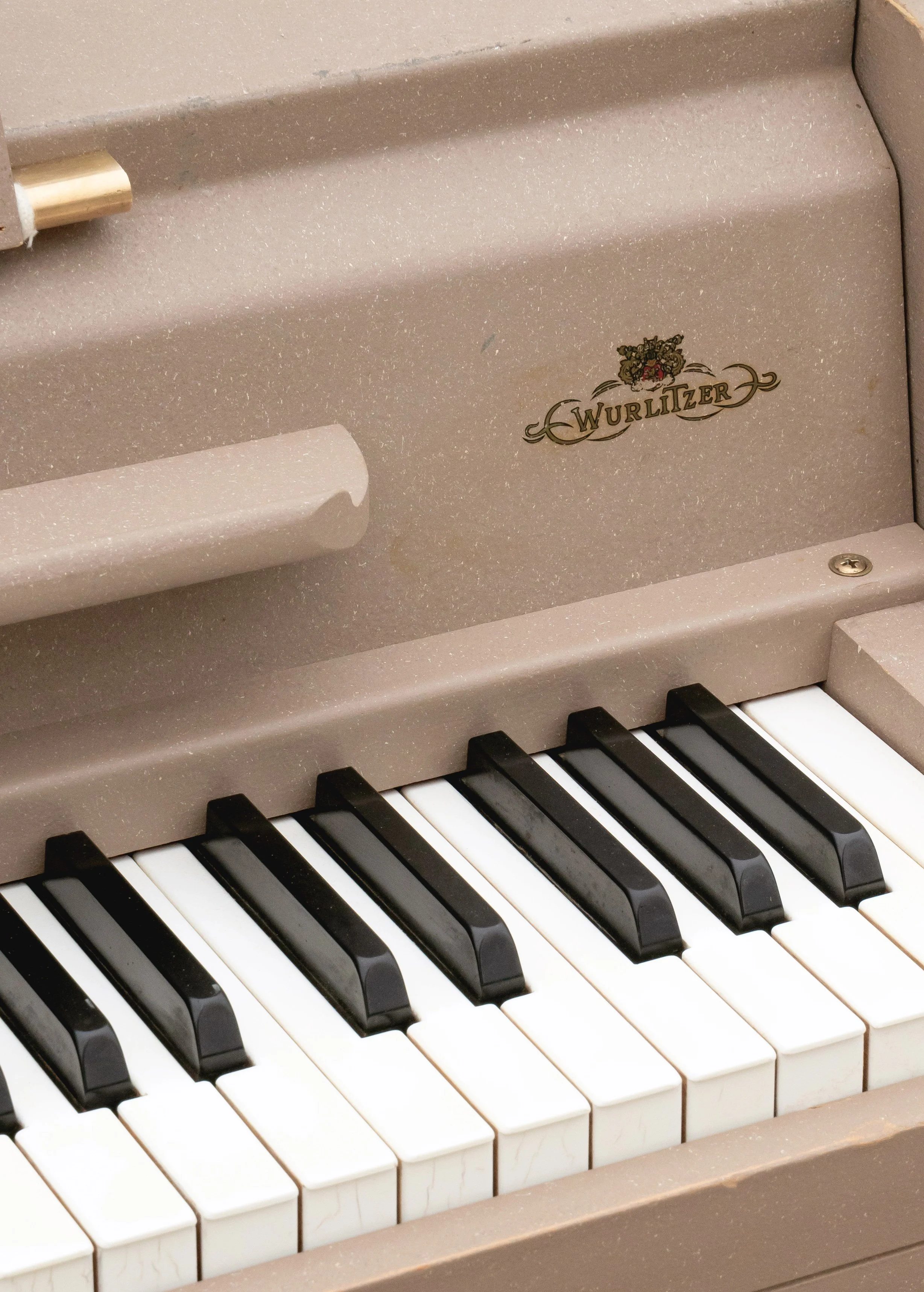 A closeup image of a Wurlitzer 140B showing the upper register keys and the Wurlitzer decal logo.