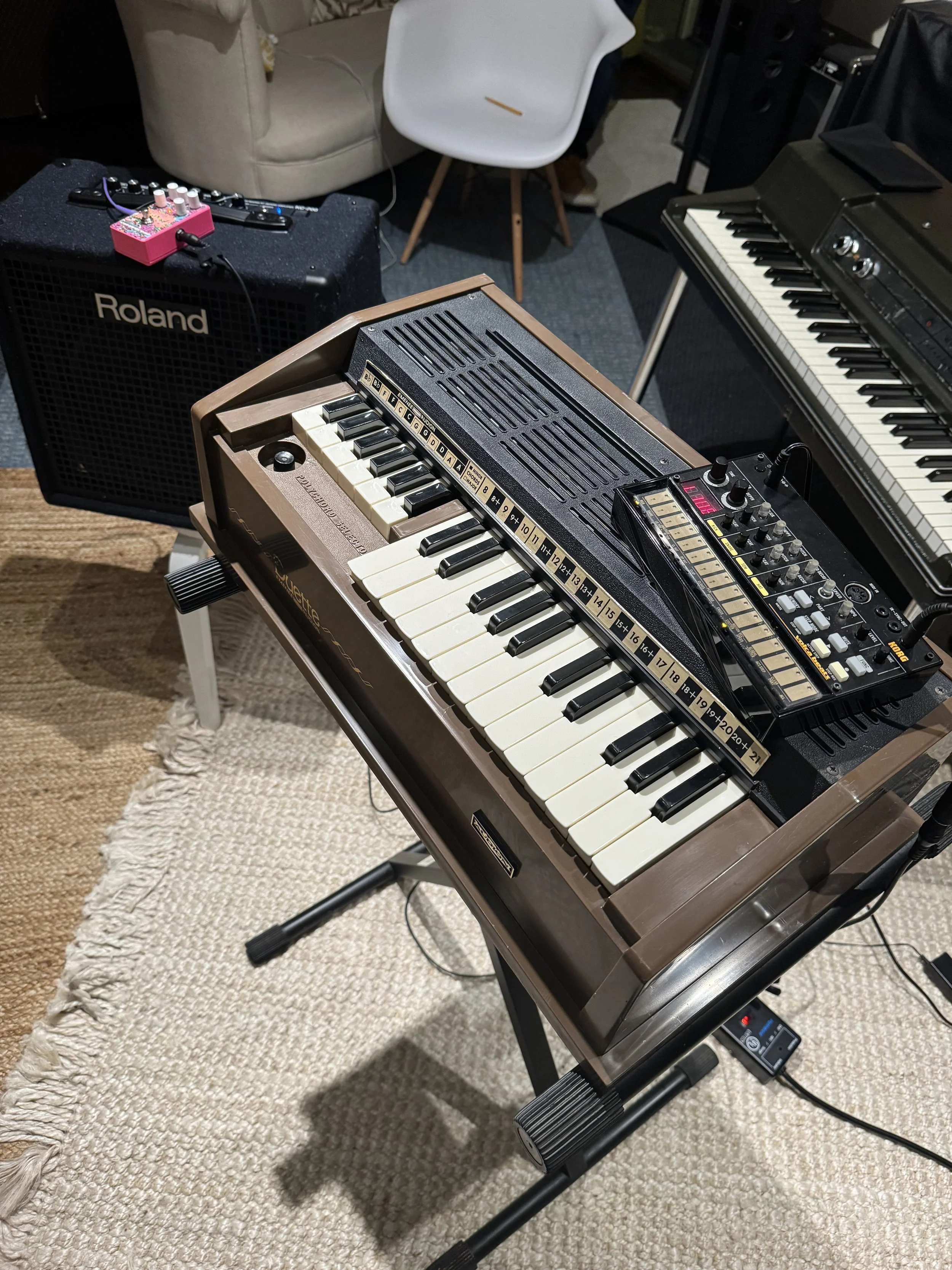 A Magnus Duette chord organ on a music stand with a small portable drum machine on top of the organ.