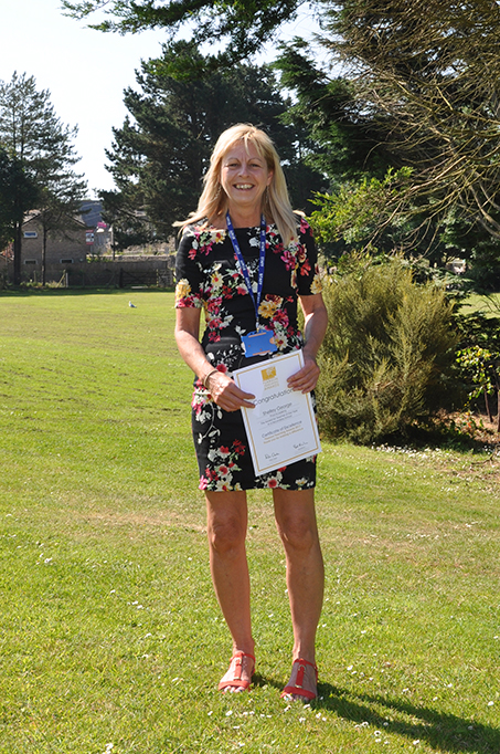 Shelley George holding her Pearson Teacher of the Year Certificate of Excellence.